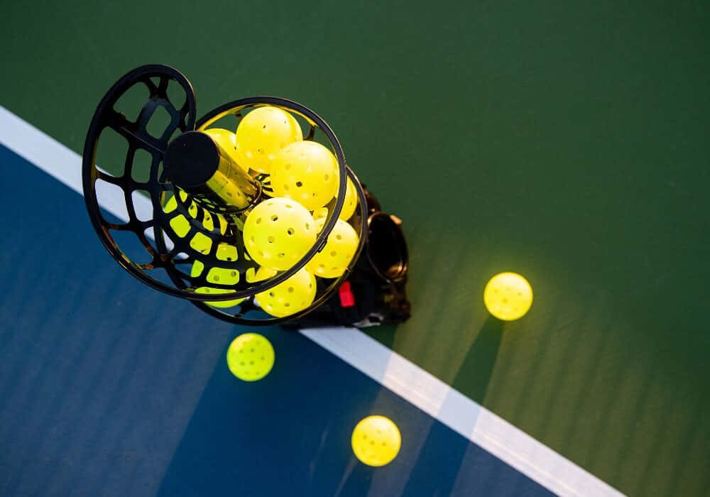 black pickleball machine, bright yellow balls, blue and green court, SD Desktop Wallpaper