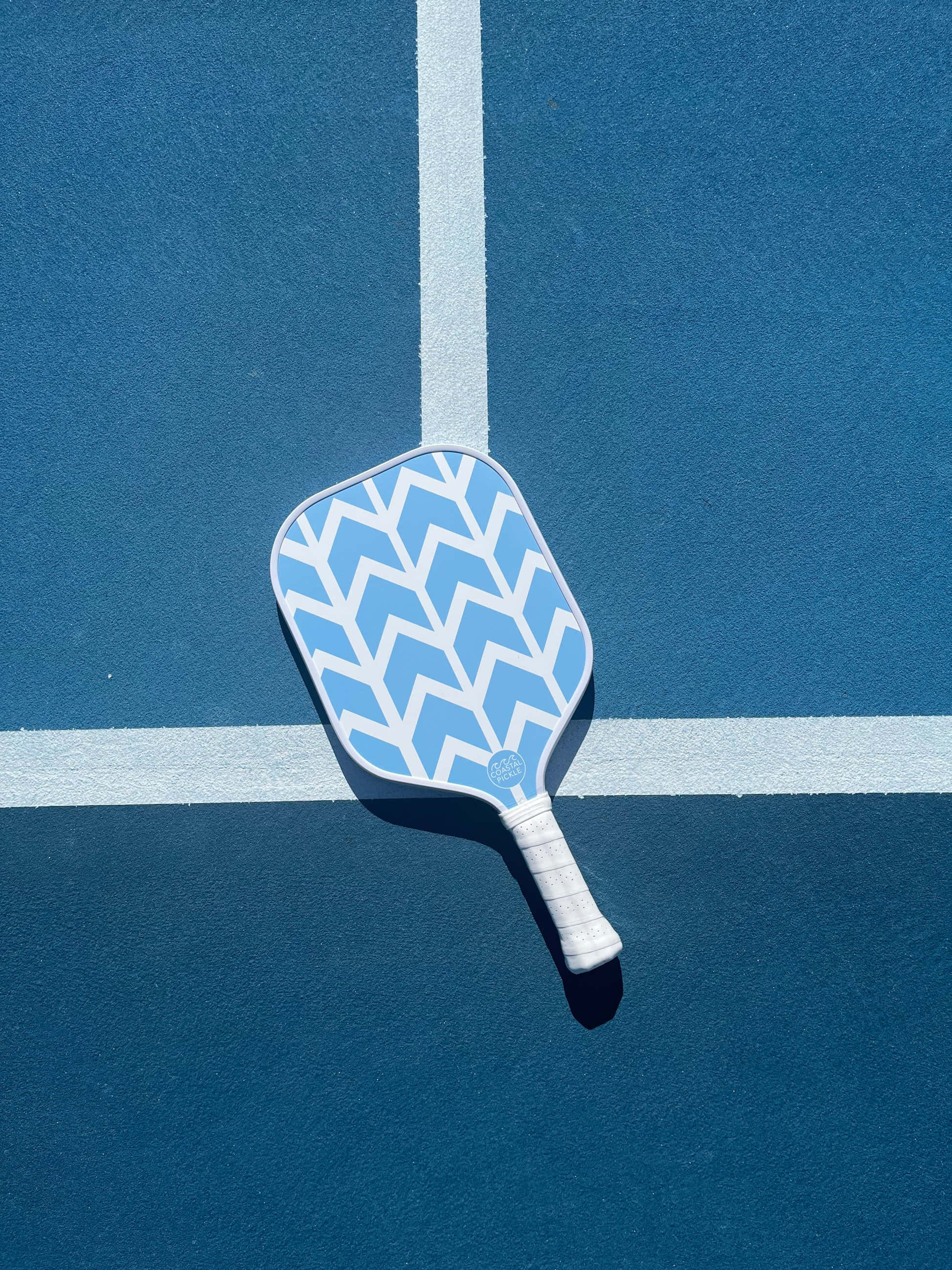 blue and white chevron-patterned pickleball paddle, vibrant blue court, crisp white lines, 2K Phone Wallpaper