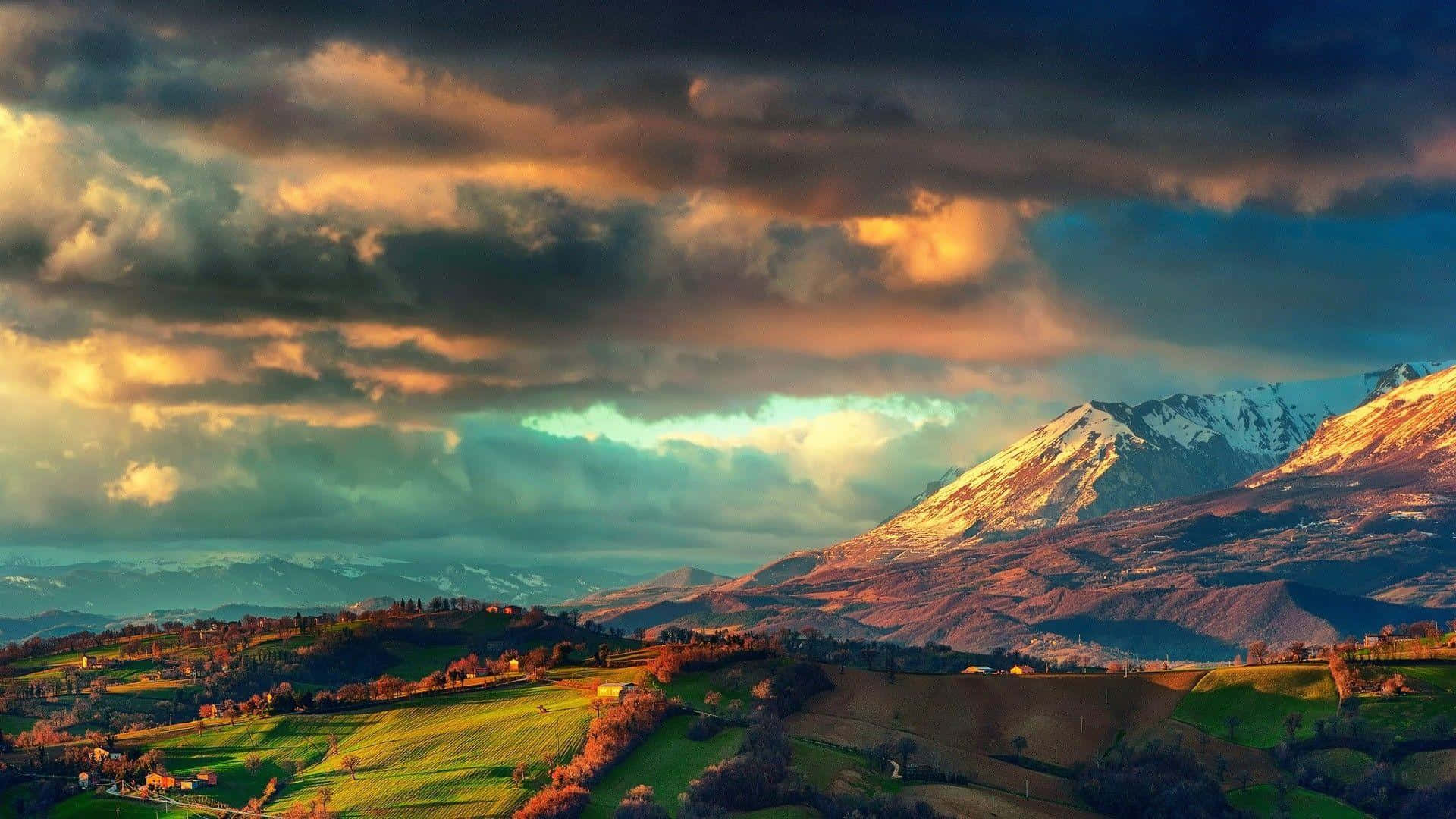 Dramatic sunset, snow capped mountains, golden light, Full HD Desktop Wallpaper