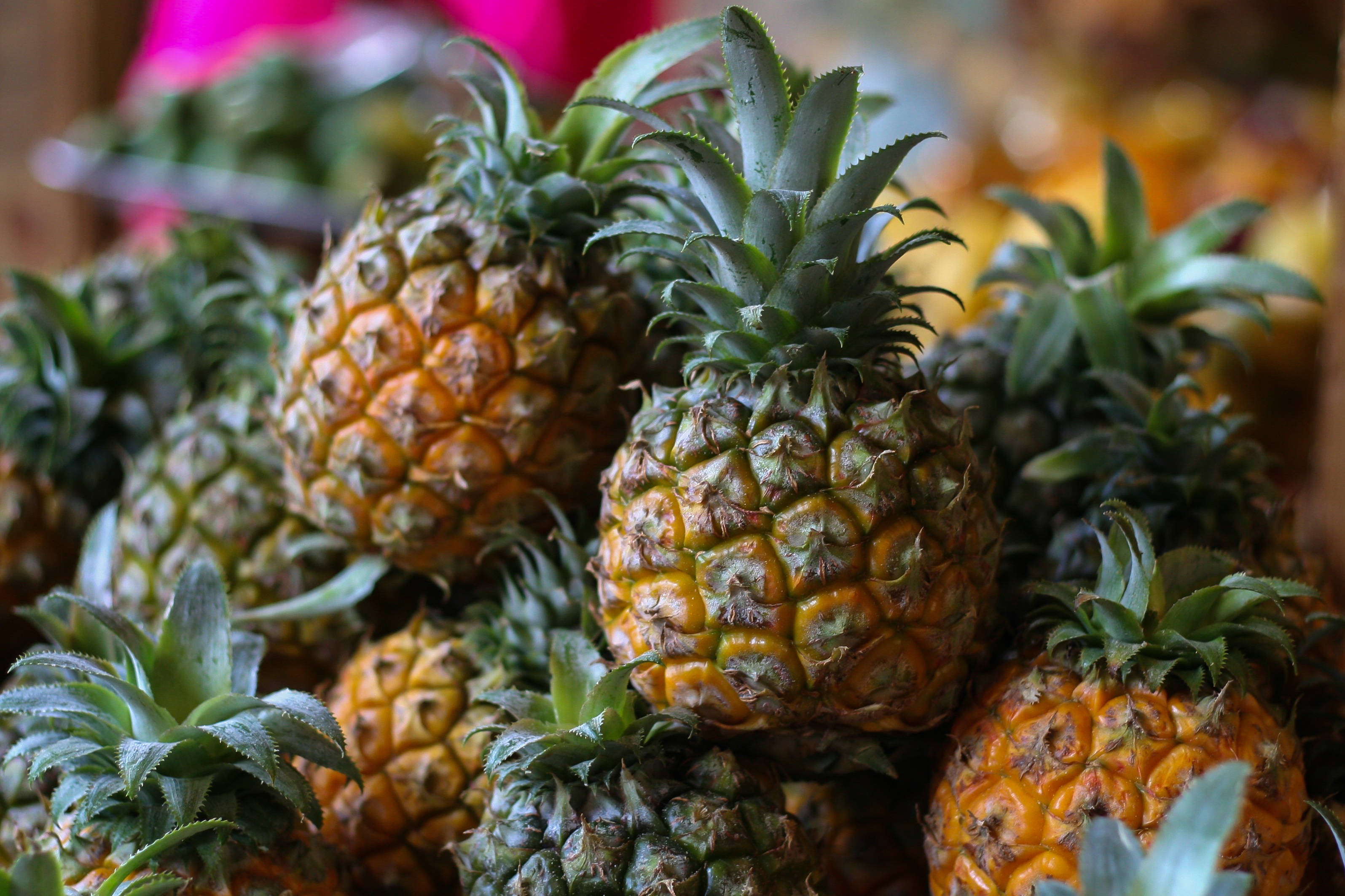 pineapple, spiky green crowns, vibrant tropical market stall, 2K Desktop Wallpaper