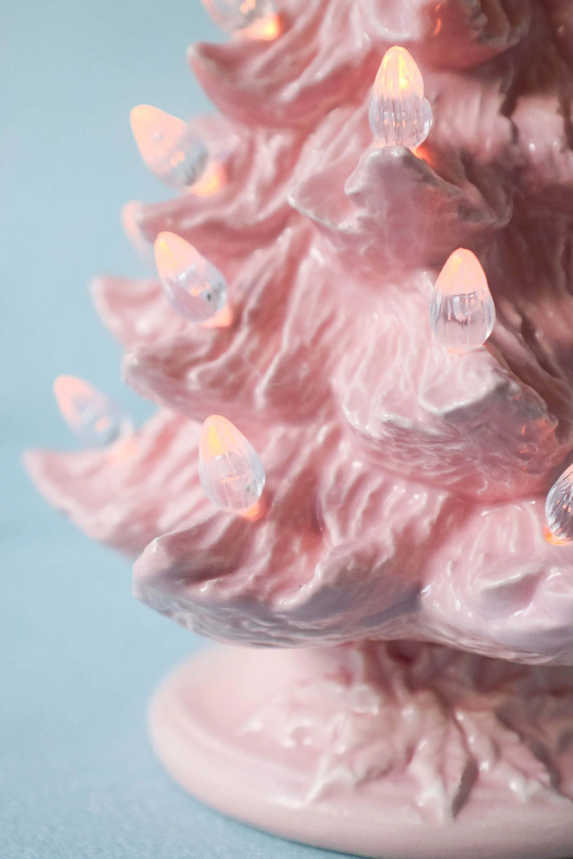 vintage pink ceramic christmas tree, glowing clear lights, soft blue background, 2K Phone Wallpaper