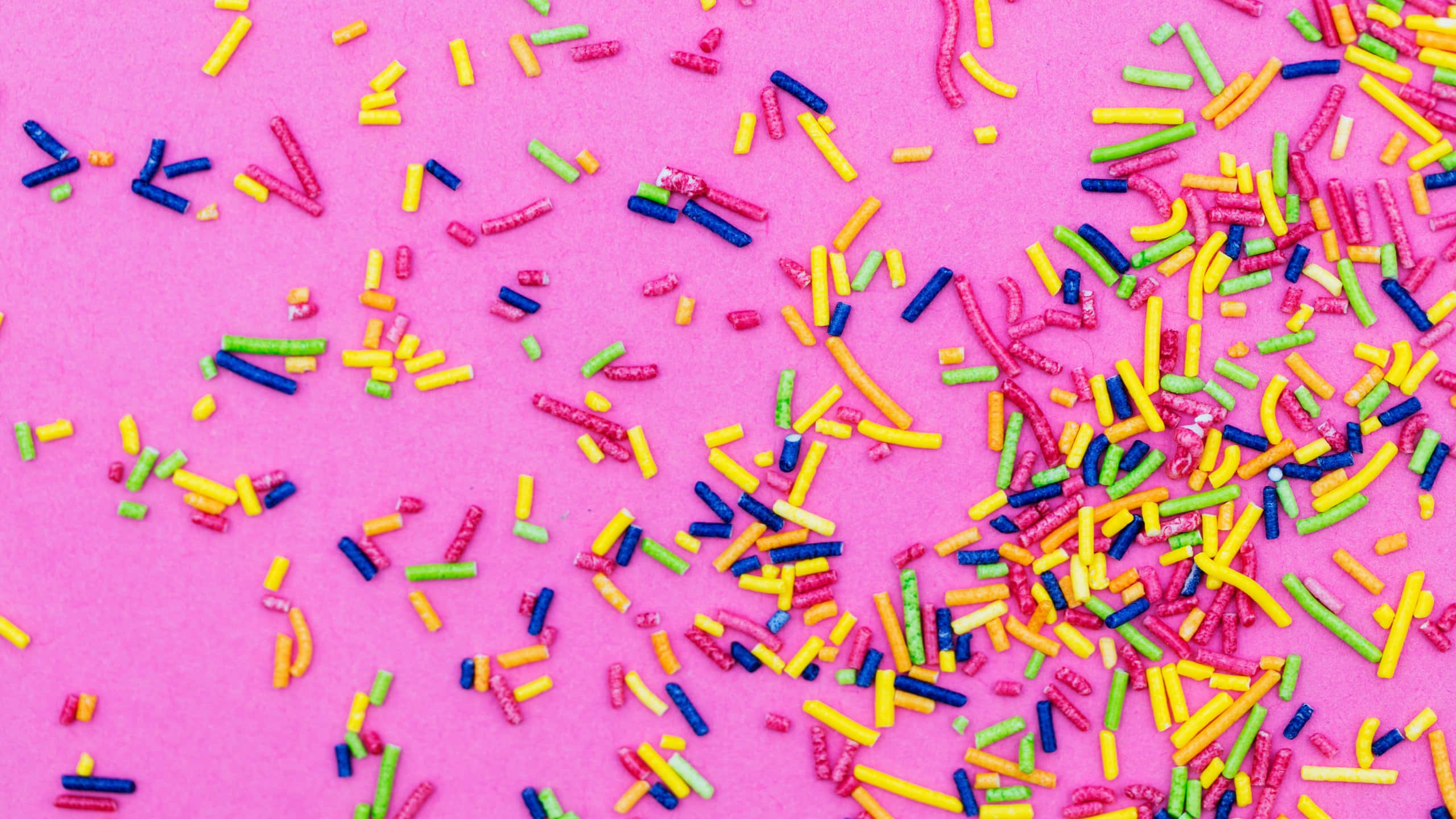 colorful sprinkles, bright pink surface, playful overhead shot, 2K Desktop Wallpaper