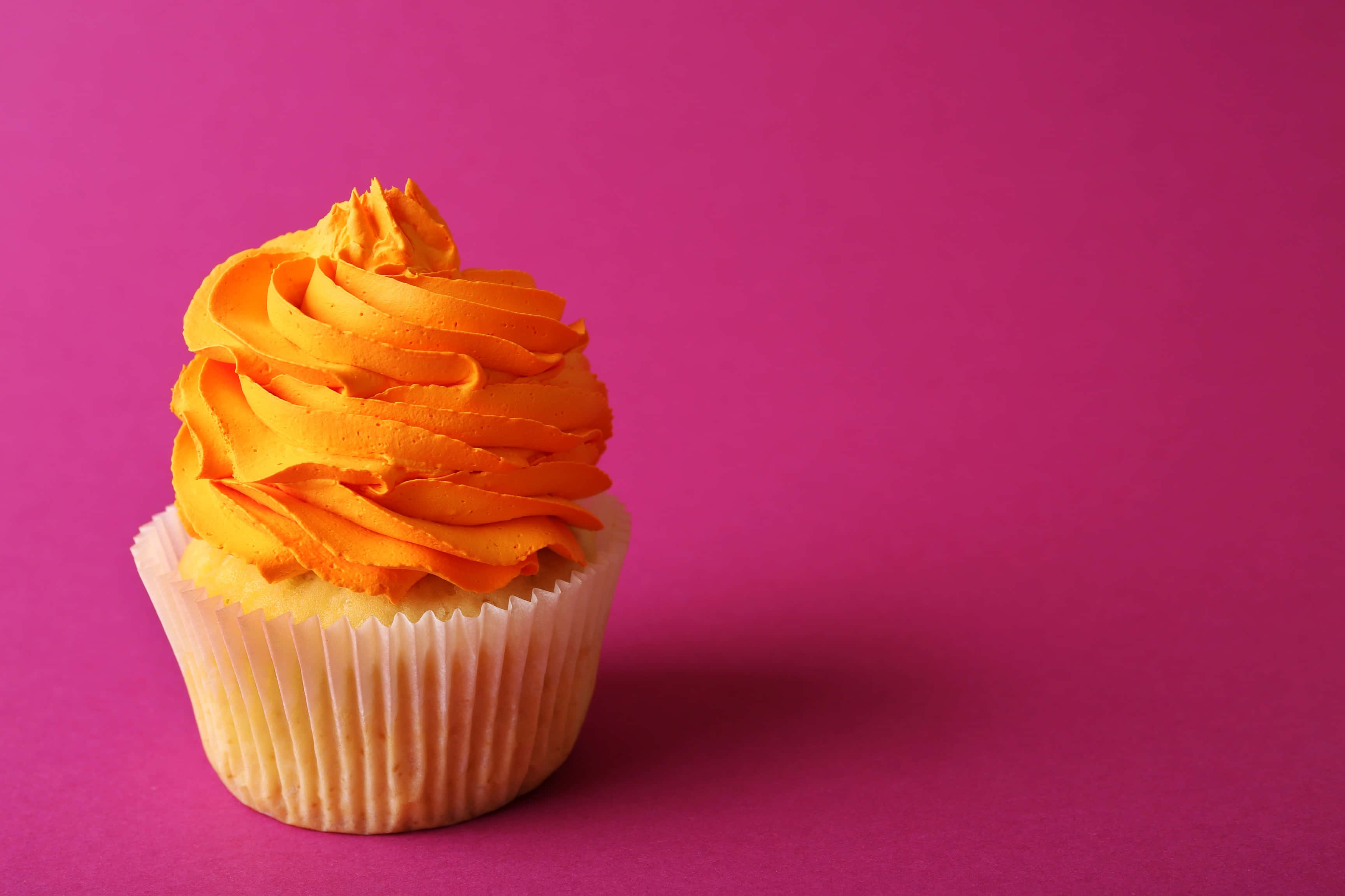 orange frosted cupcake, magenta background, pink background, 2K Desktop Wallpaper
