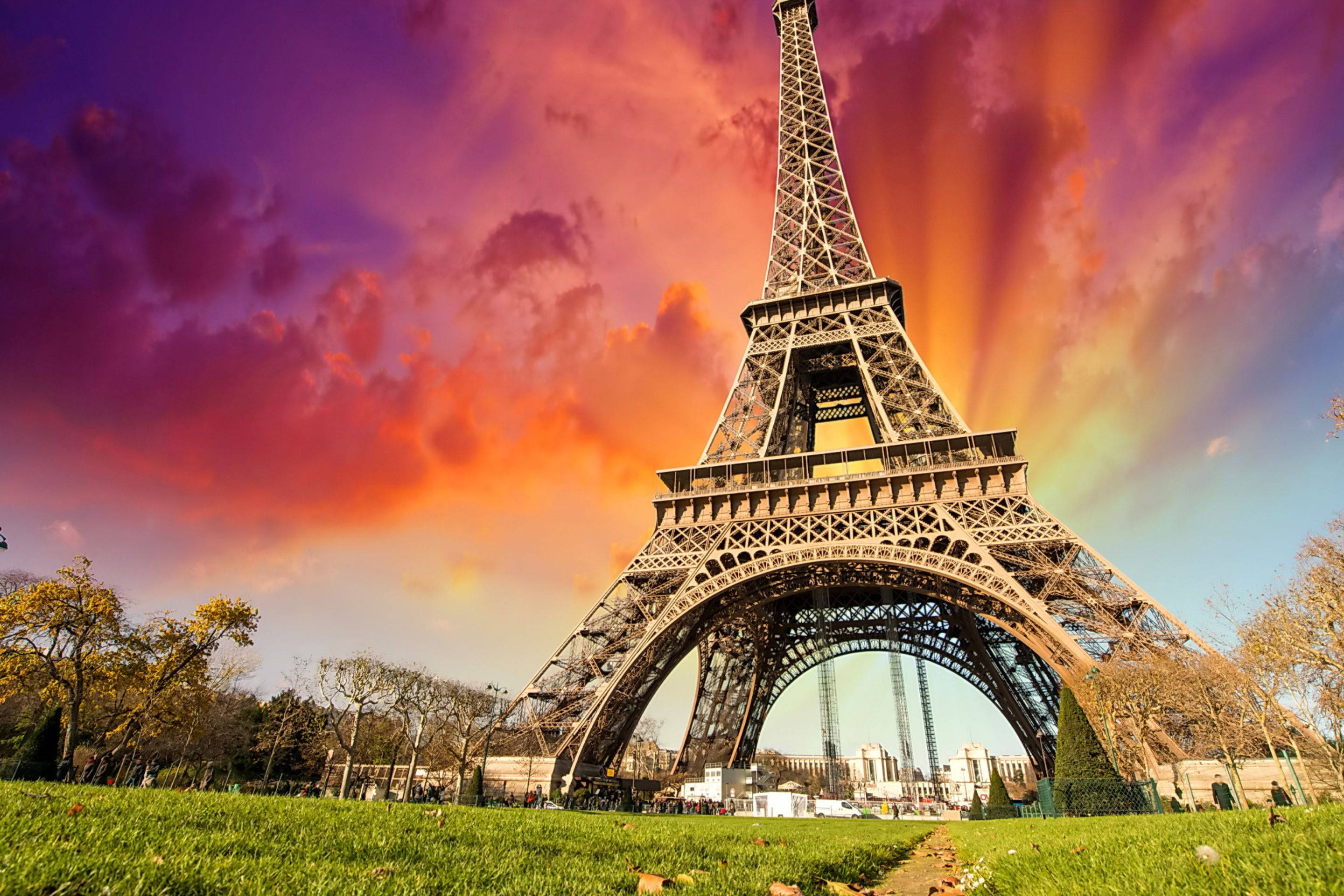 Pink Eiffel Tower, vibrant sunset sky, fiery orange and purple clouds, 2K Desktop Wallpaper