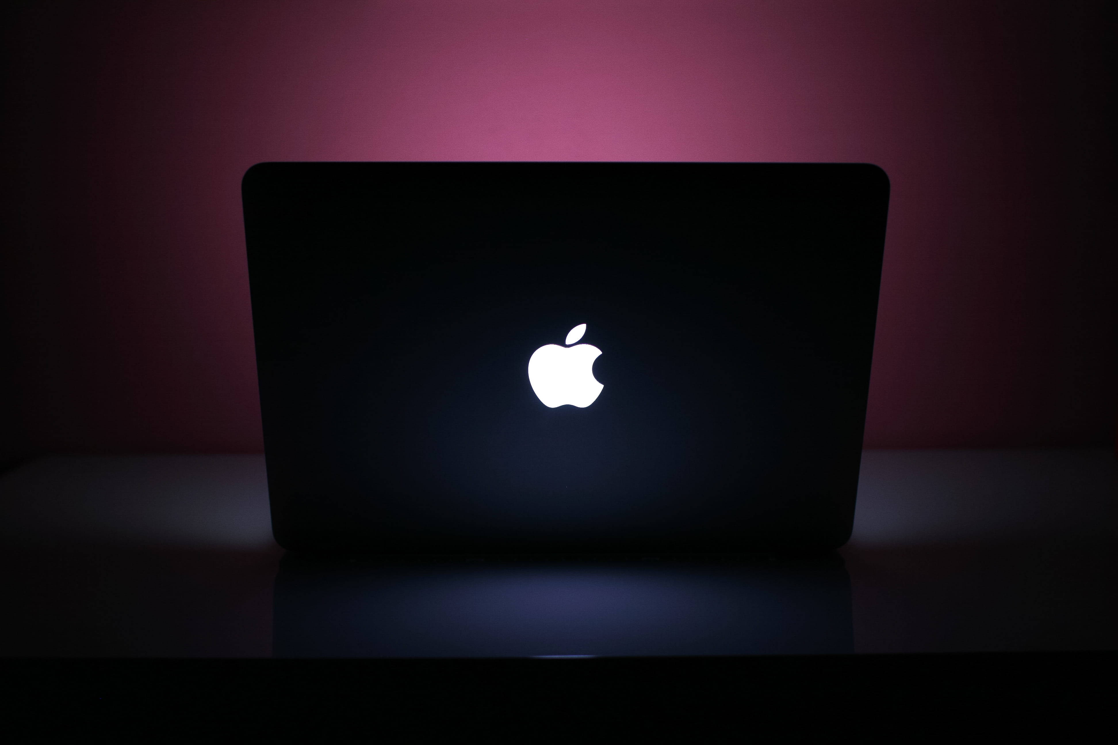 black and pink aesthetic, glowing white Apple logo, dark surface, 4K Desktop Wallpaper
