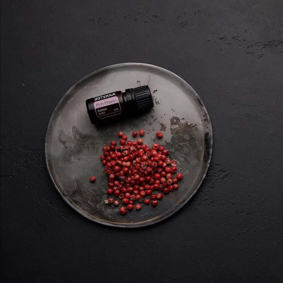 Pink Peppercorn, doTERRA essential oil bottle, dark gray ceramic plate, SD Desktop Wallpaper