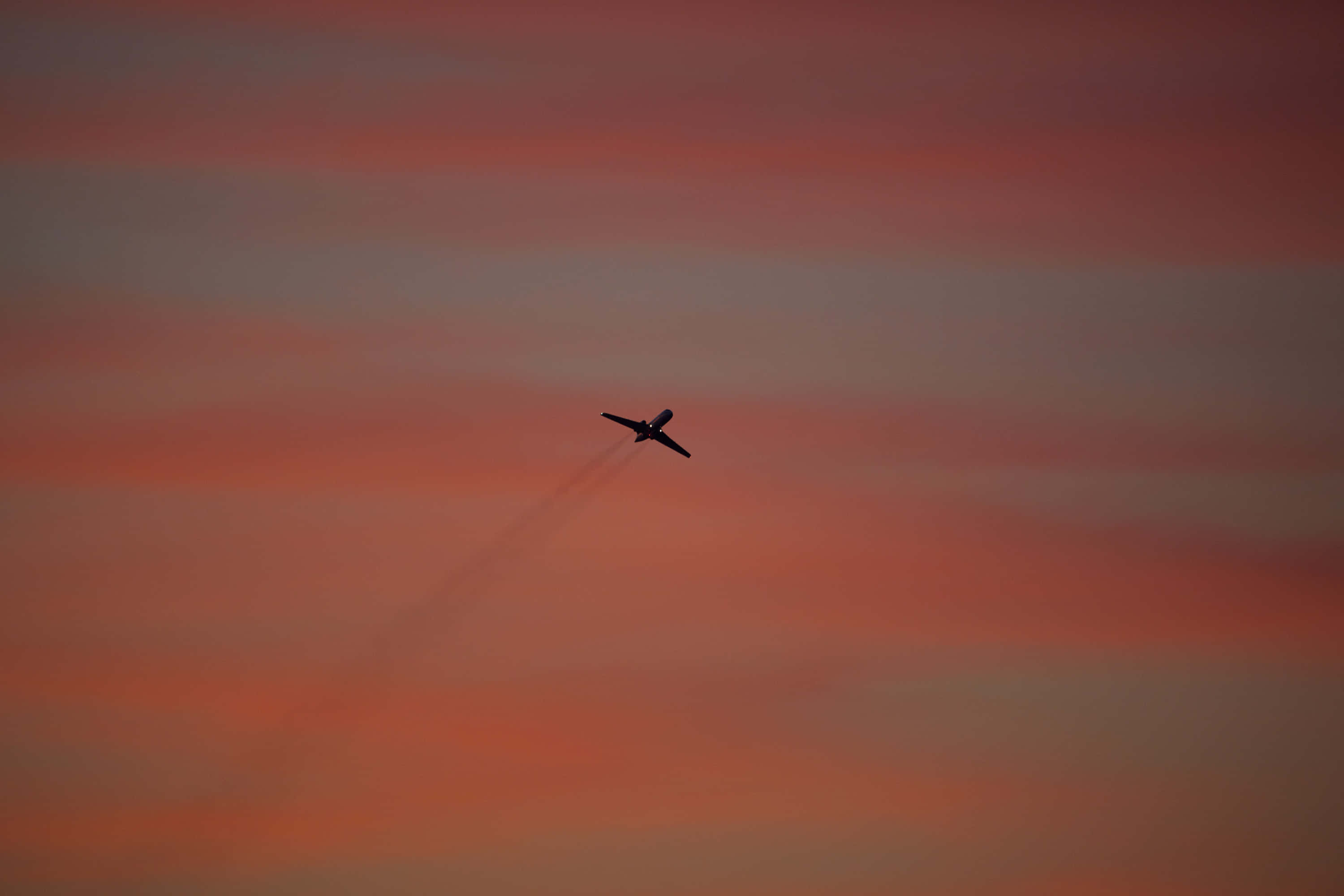 pink plane, vibrant orange and pink sunset sky, trail of smoke, 2K Desktop Wallpaper