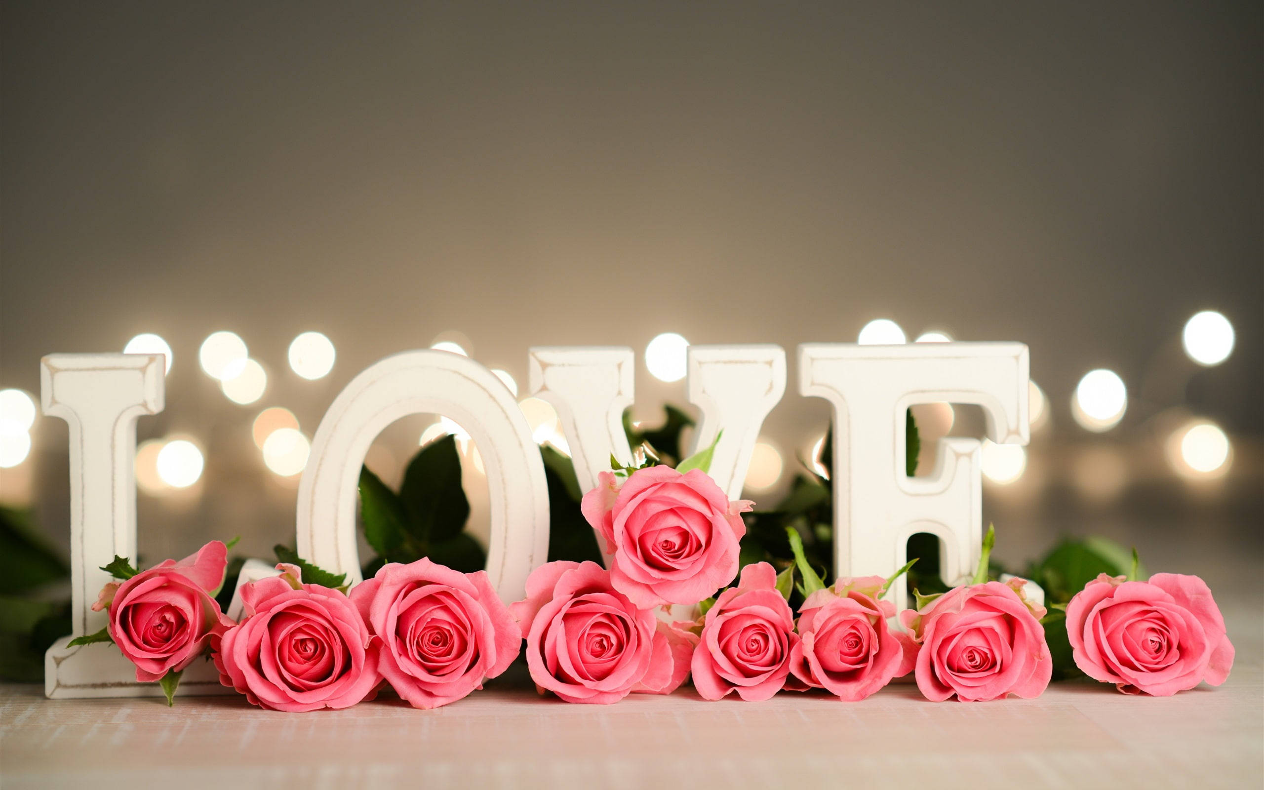 Pink Roses, white 'LOVE' letters, warm bokeh lights, 2K Desktop Wallpaper