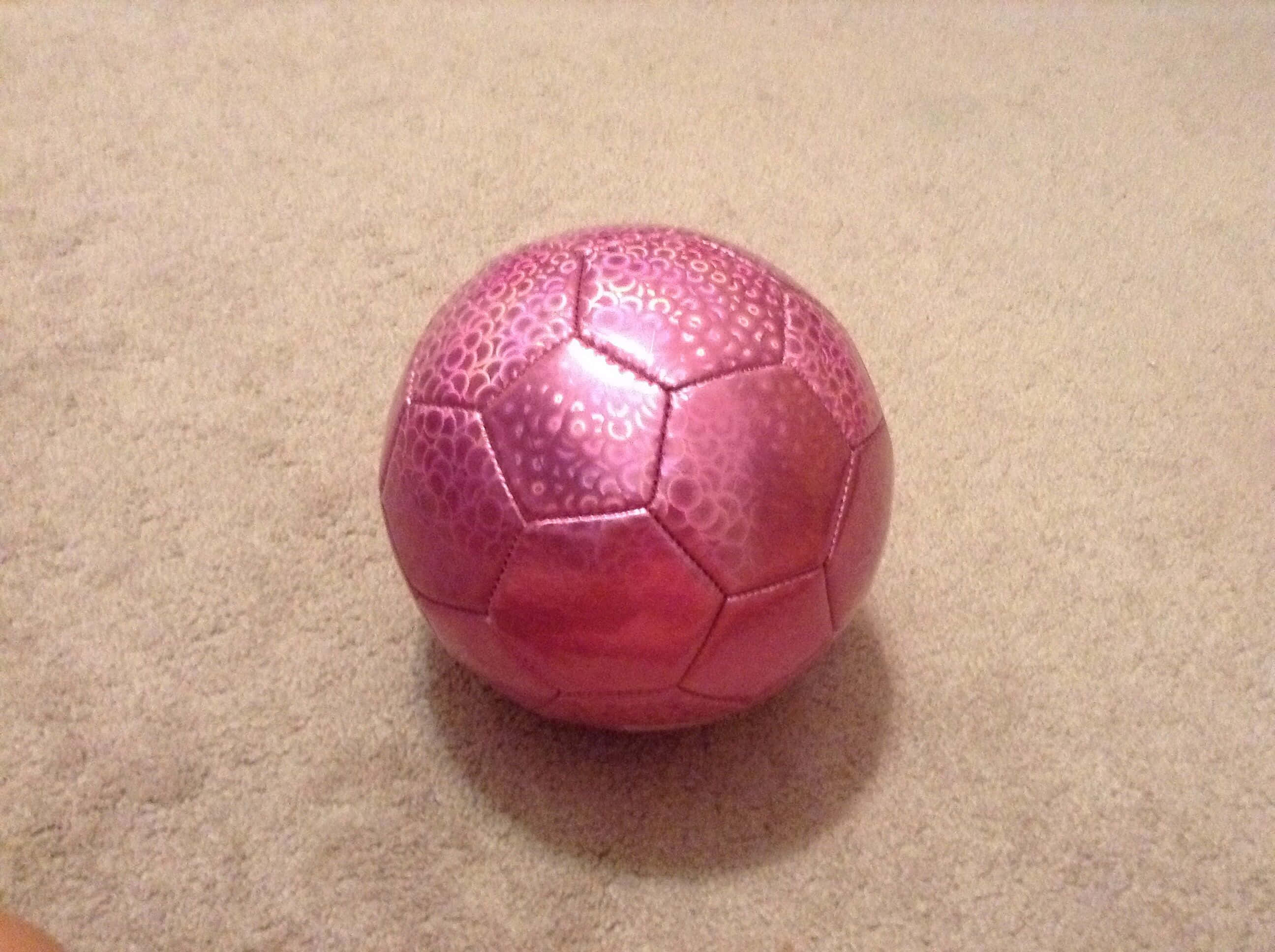 pink soccer ball, hexagonal panels, green grass field, 2K Desktop Wallpaper