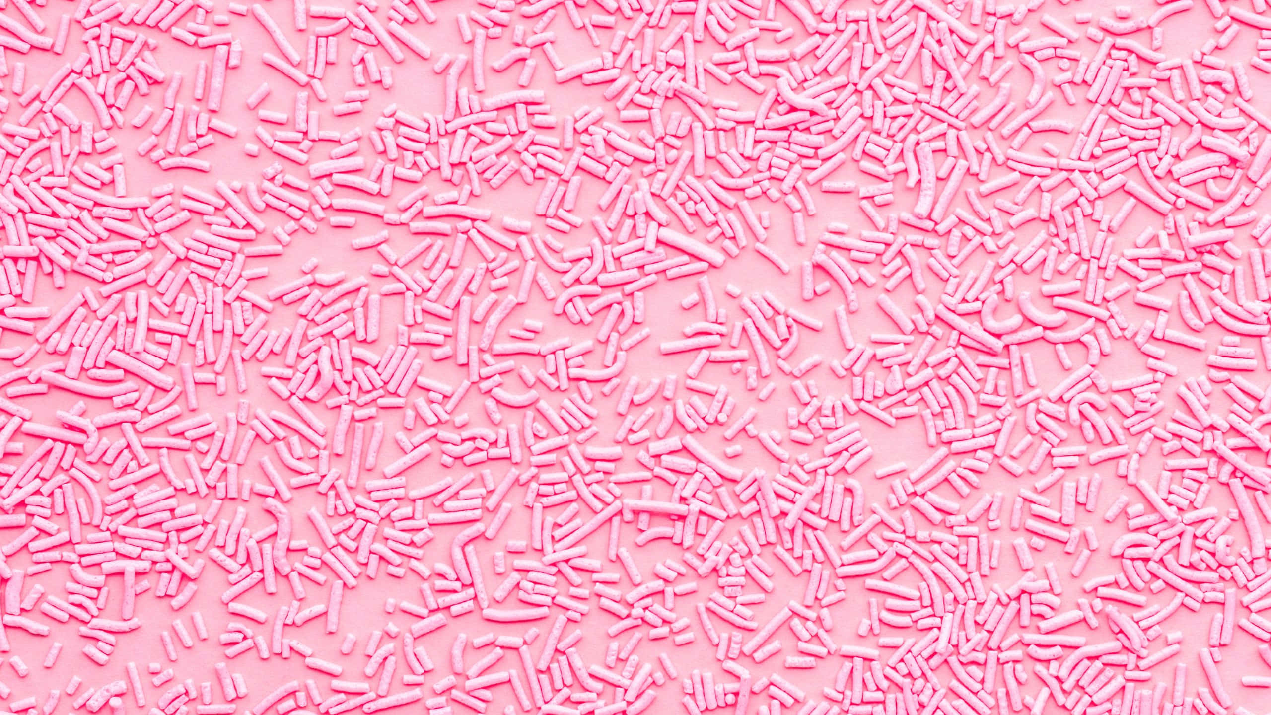 pink sprinkles, soft pink surface, sweet textured background, 2K Desktop Wallpaper