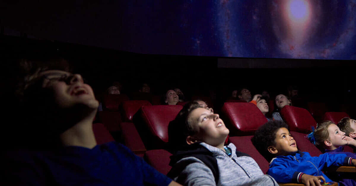 Planetarium, red theater seats, cosmic galaxy projection, SD Desktop Wallpaper