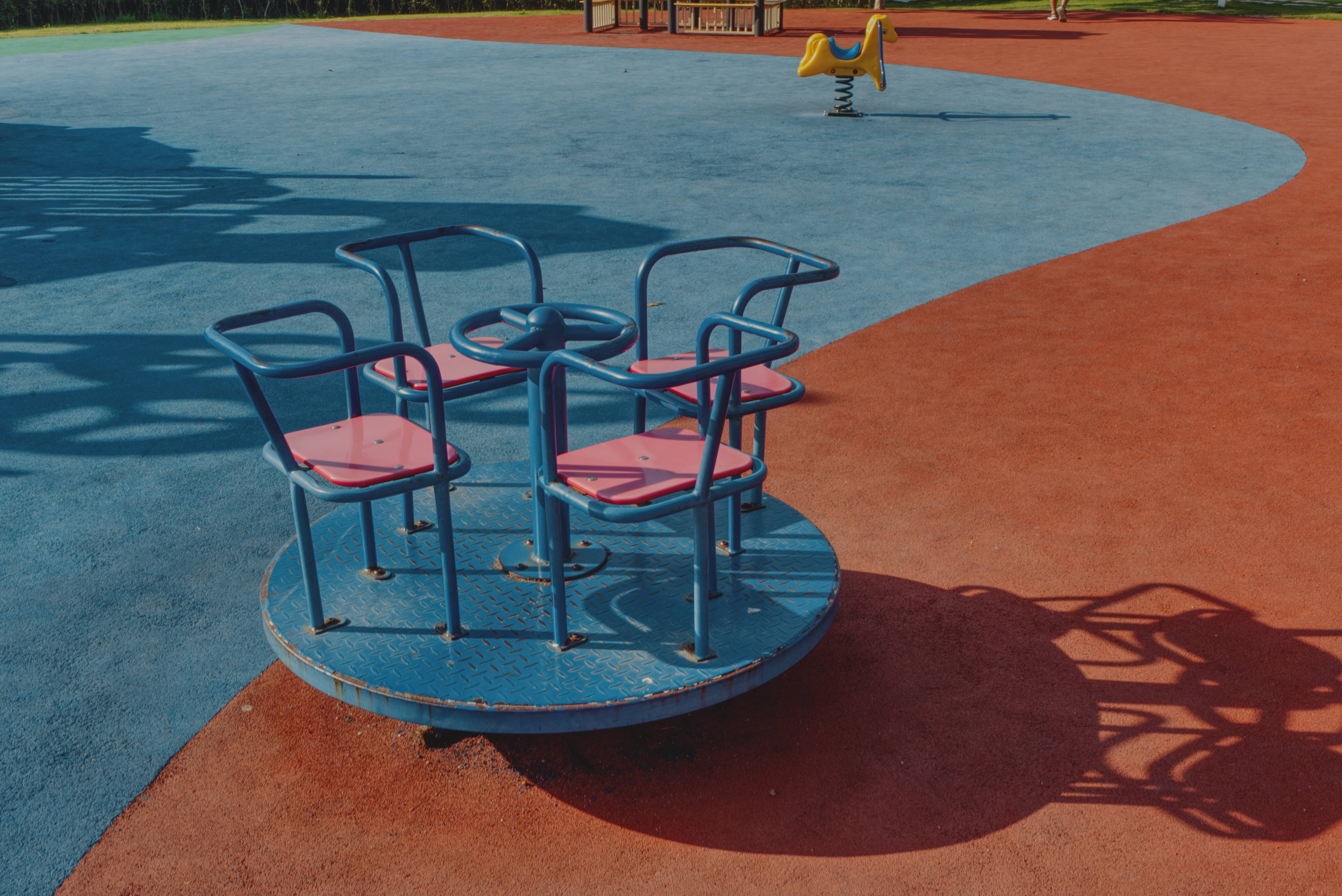 playground merry-go-round, blue and pink, red and blue safety surfacing, 5K Desktop Wallpaper