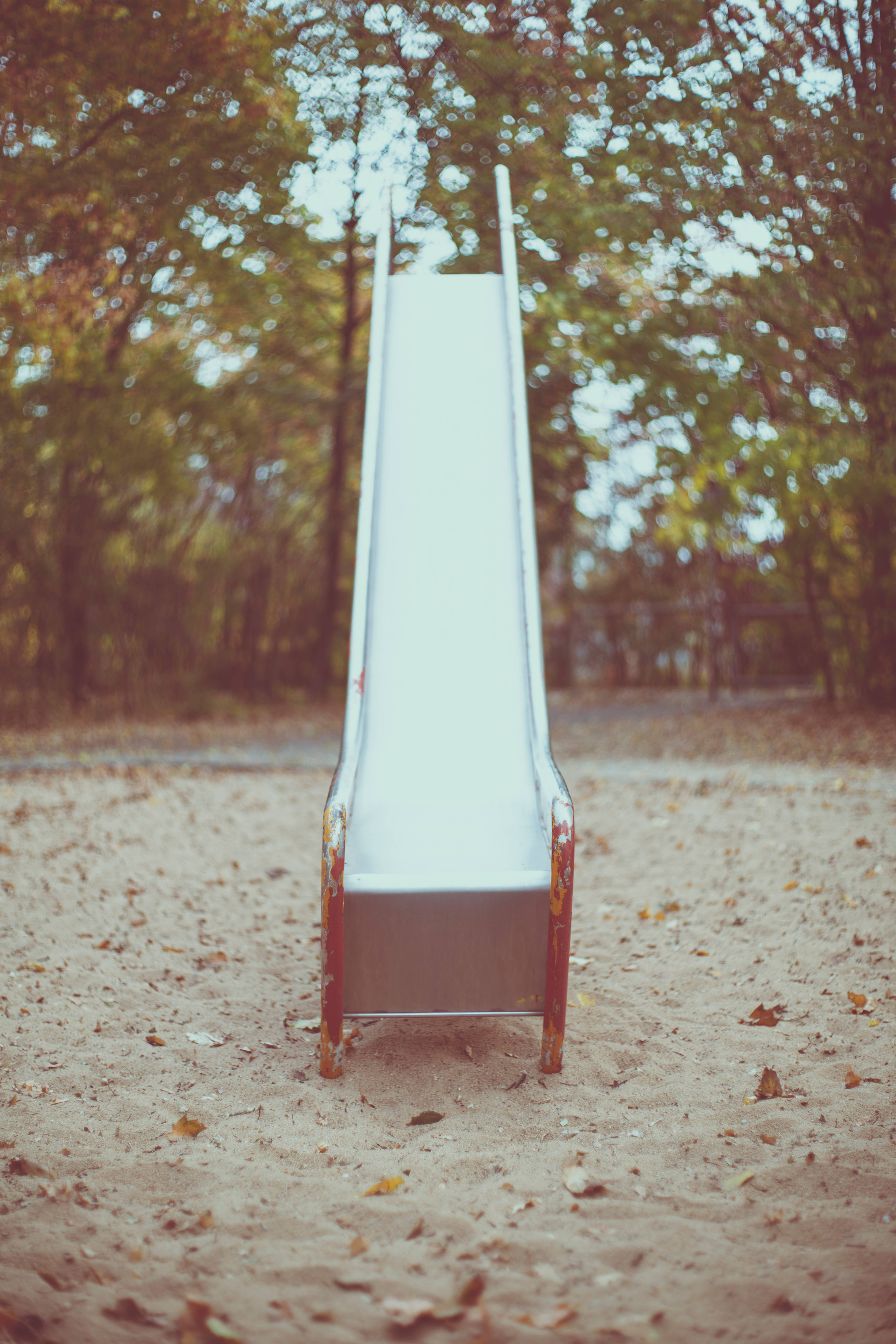 straight playground slide, weathered white, sandy park, 5K Phone Wallpaper