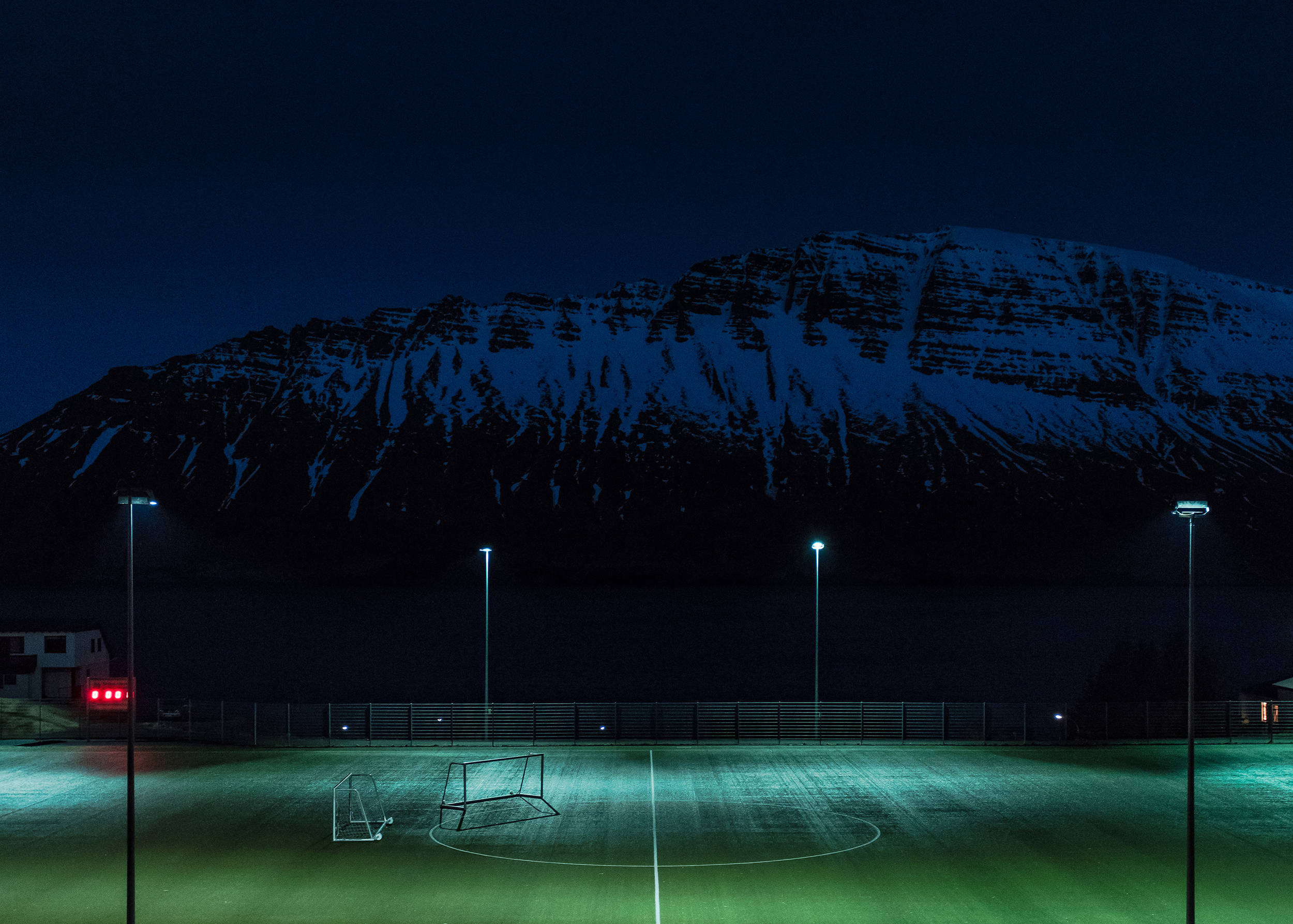 night football field, snow-capped mountain, glowing green turf, Full HD Desktop Wallpaper