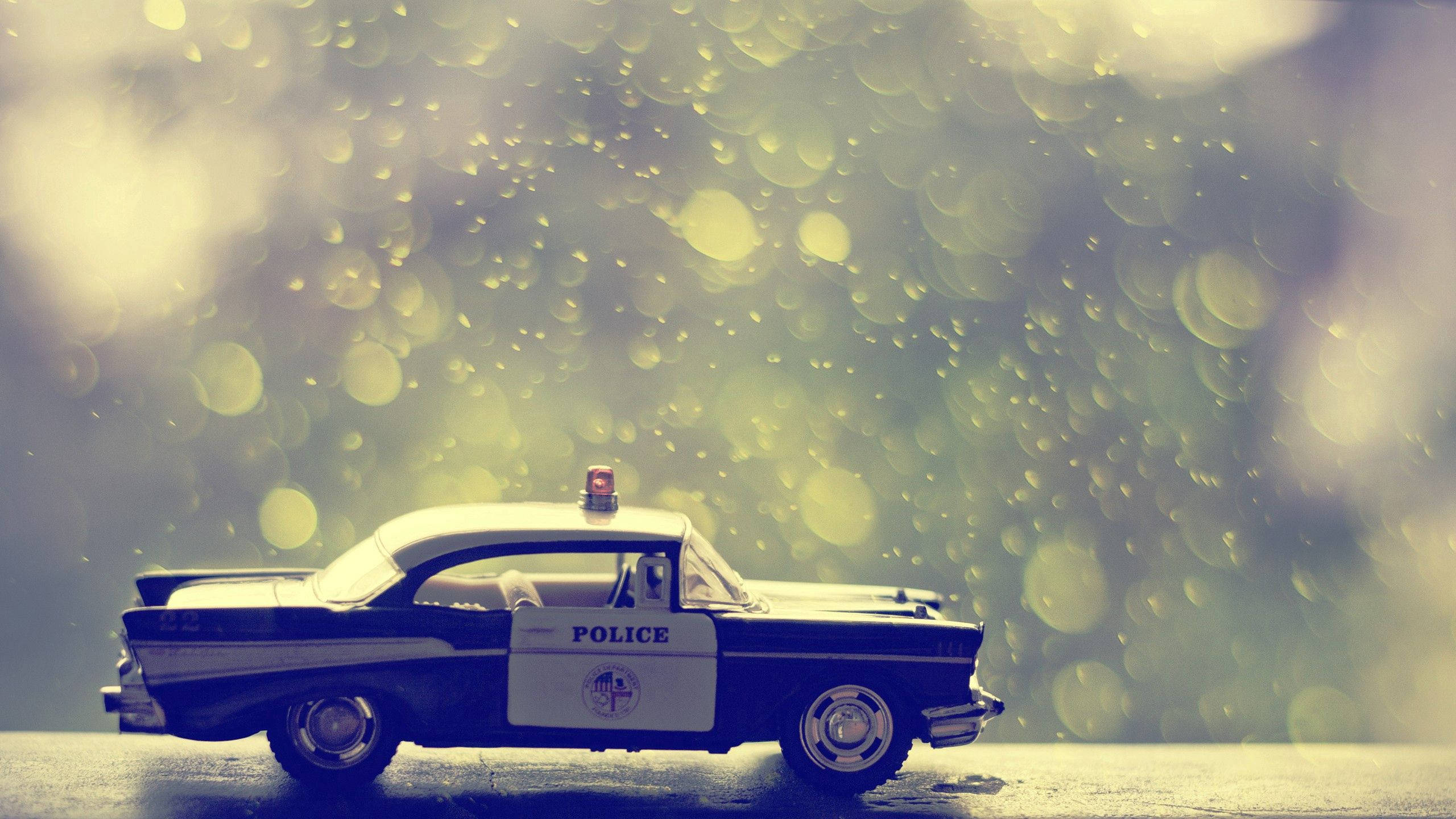 toy police car, vintage police car toy, wet pavement, 2K Desktop Wallpaper