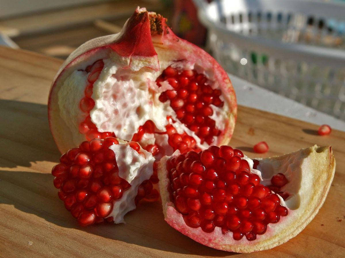 pomegranate, red arils, sunlit wooden surface, SD Desktop Wallpaper