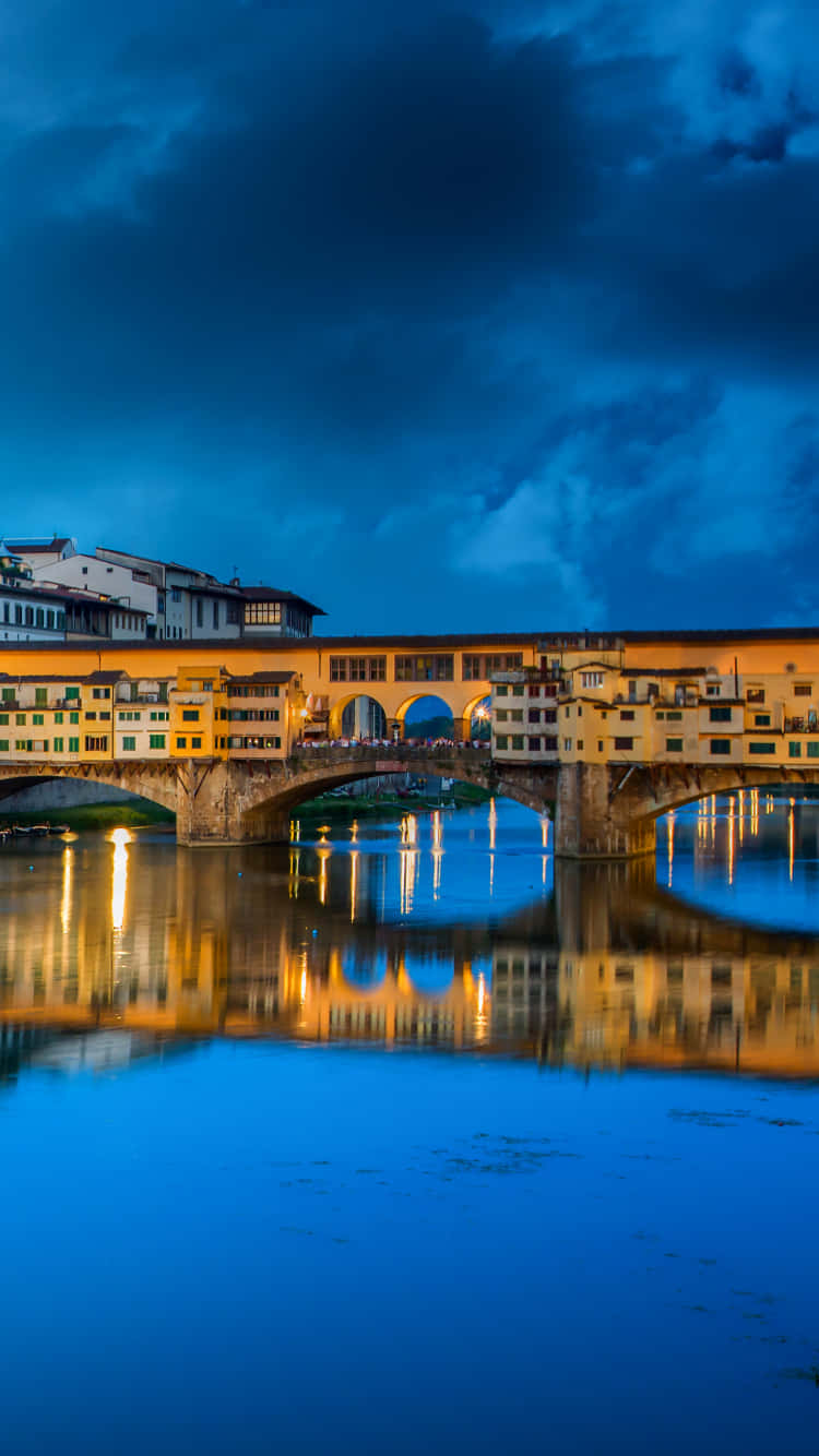 Ponte Vecchio, glowing yellow buildings, calm blue water, HD Phone Wallpaper