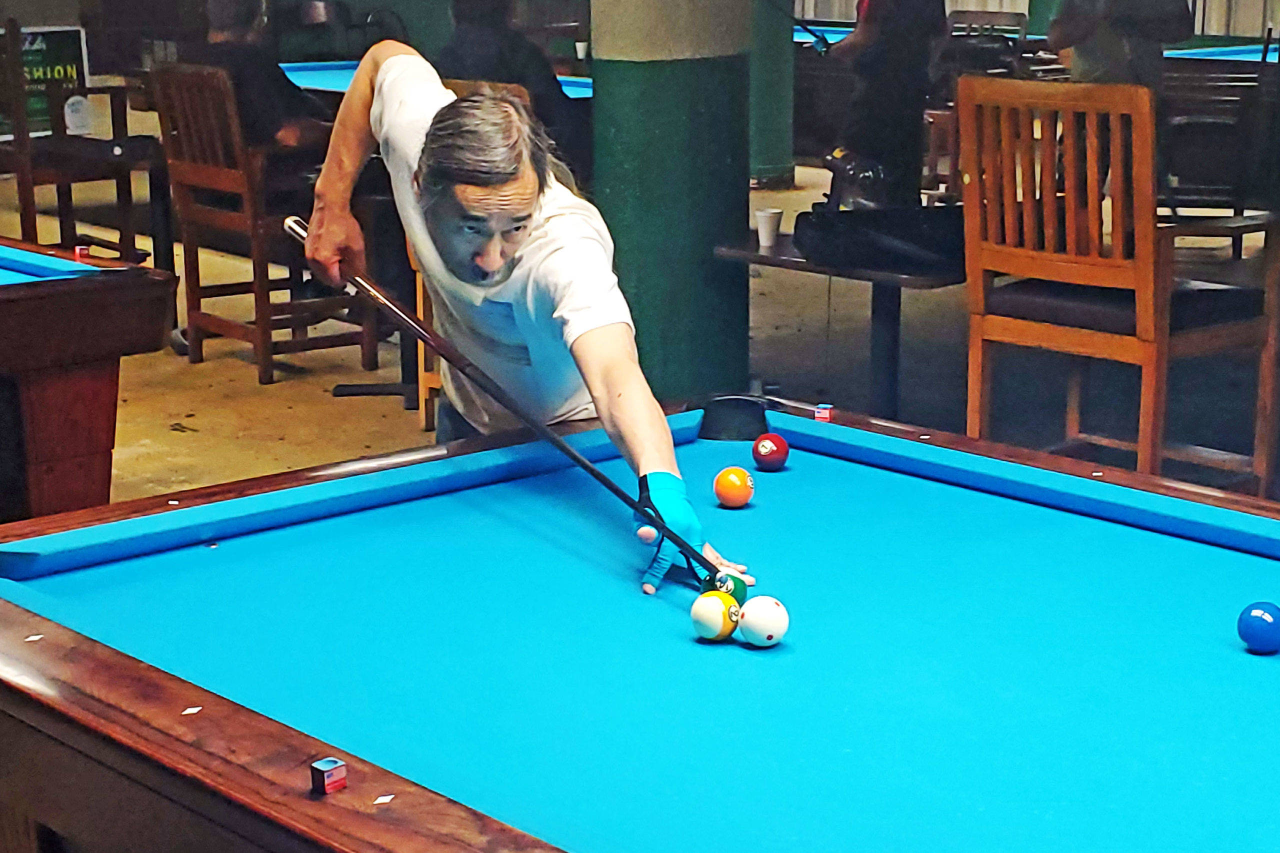 blue pool table, dimly lit bar, focused man in a white shirt and blue glove, 2K Desktop Wallpaper