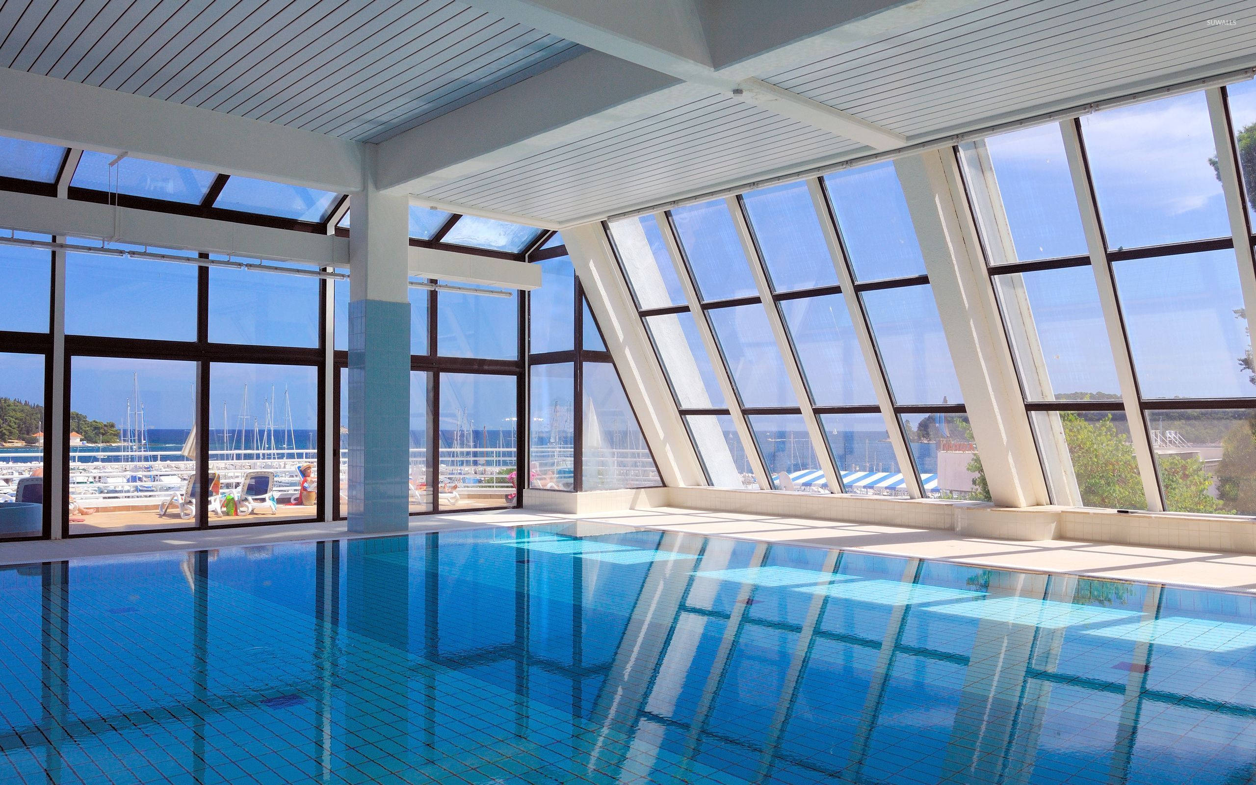 indoor swimming pool, clear blue water, glass windows, 2K Desktop Wallpaper