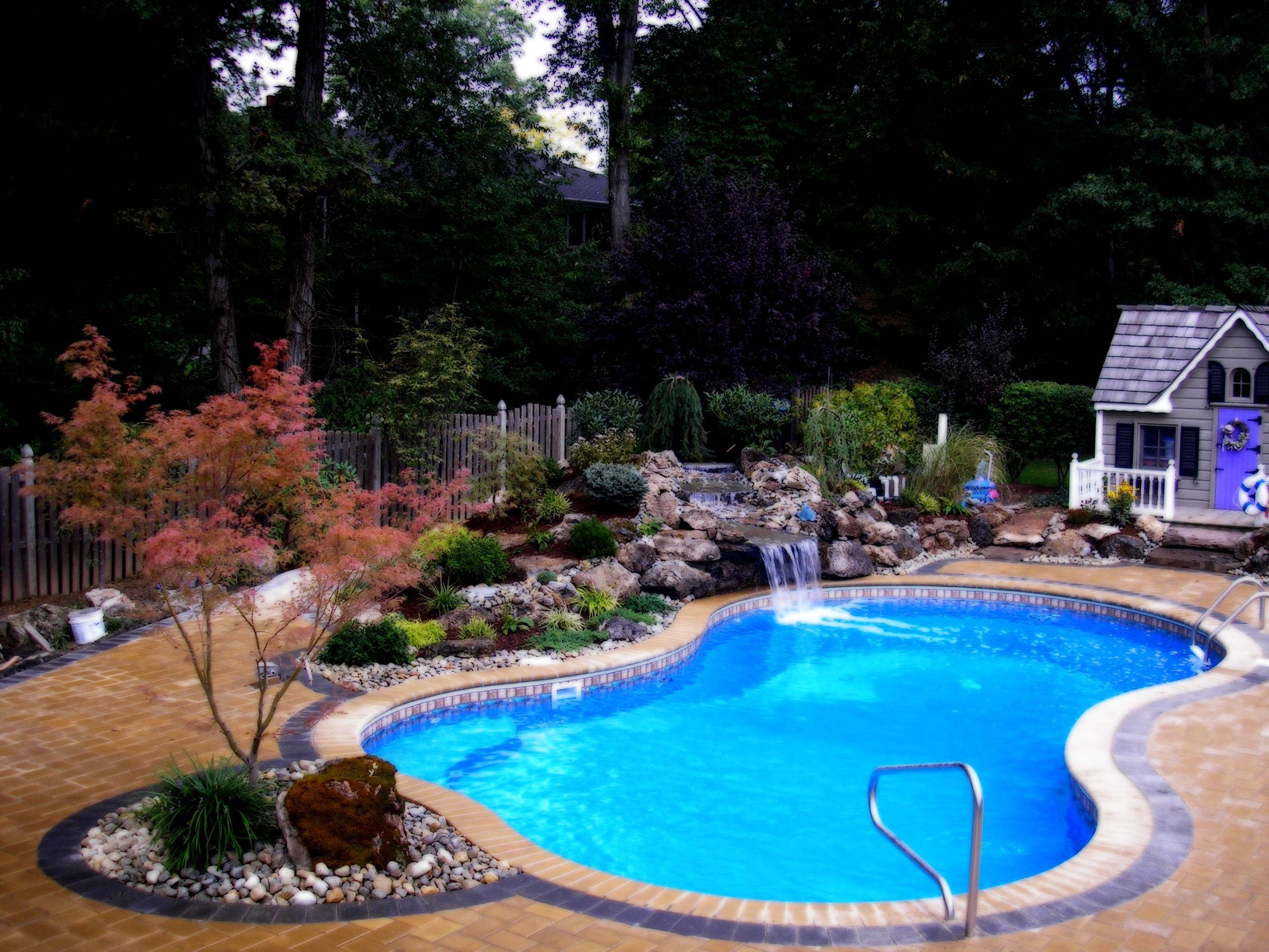 eight shaped swimming pool, vibrant blue, cascading waterfall, 2K Desktop Wallpaper