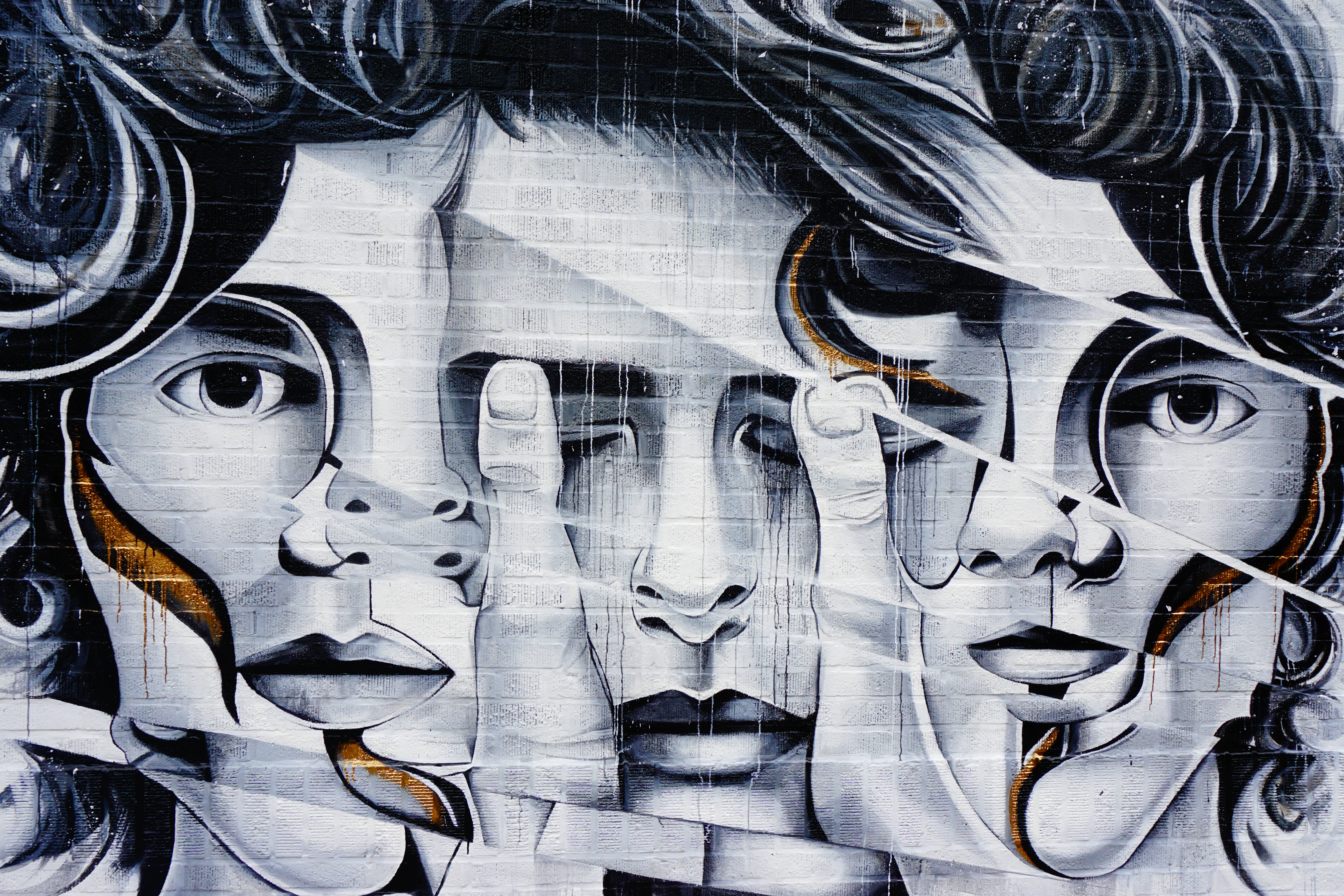 black and white graffiti mural, three stylized faces, dramatic curls, 5K Desktop Wallpaper