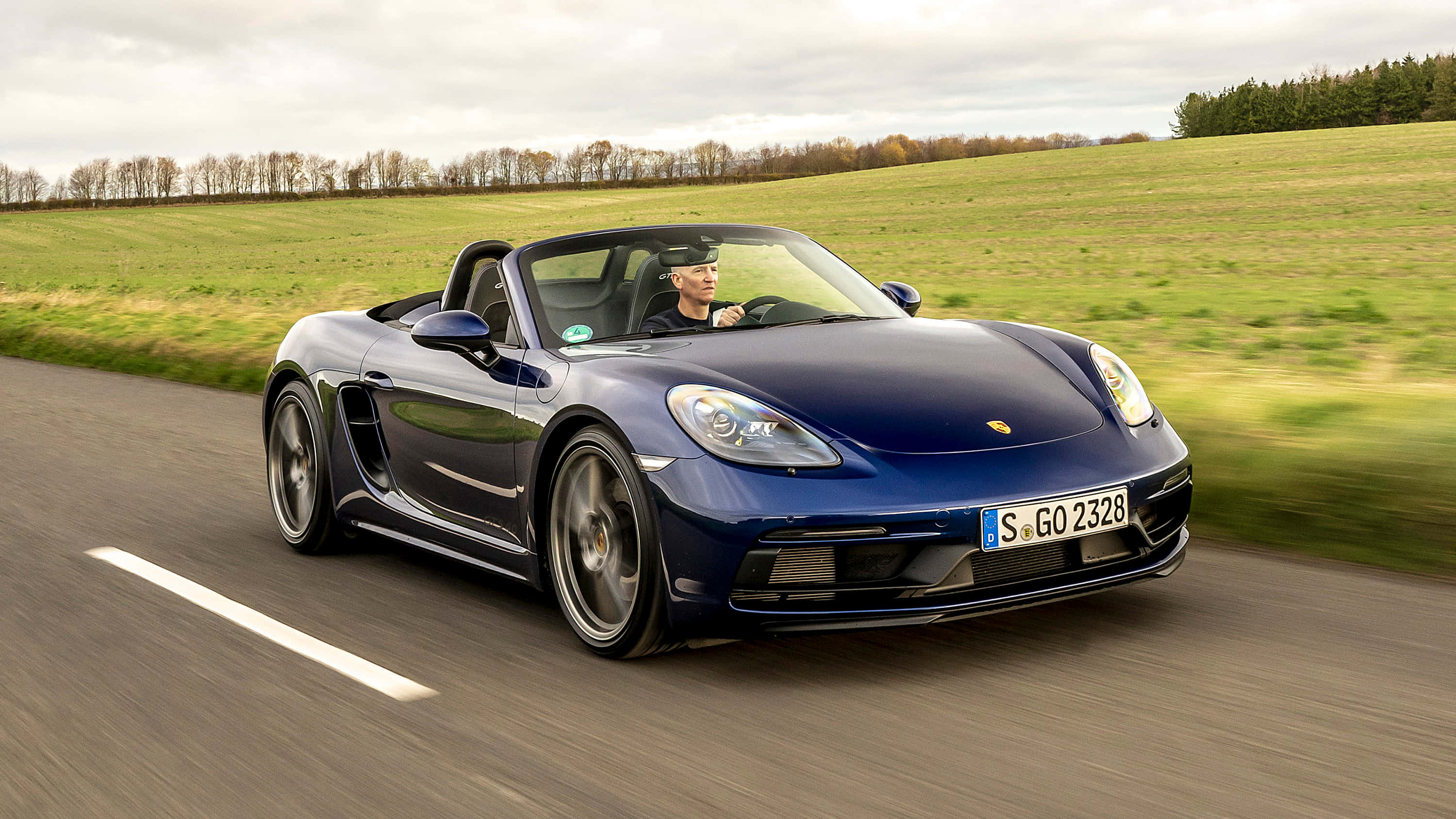 Porsche 718 Boxster GTS, sleek blue, rural road, 2K Desktop Wallpaper