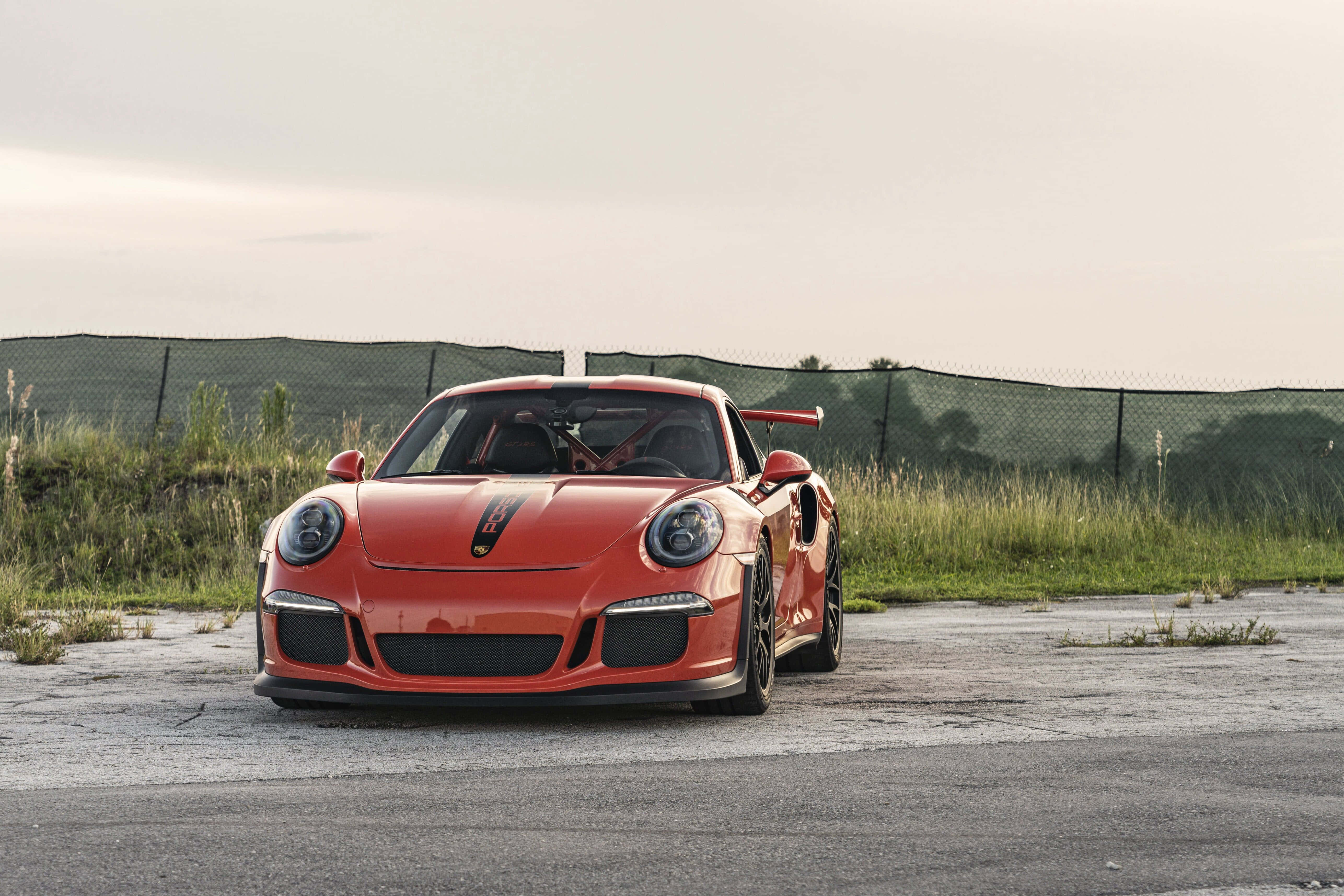 Porsche 911 GT3 RS, vibrant orange, cracked asphalt, 5K Desktop Wallpaper