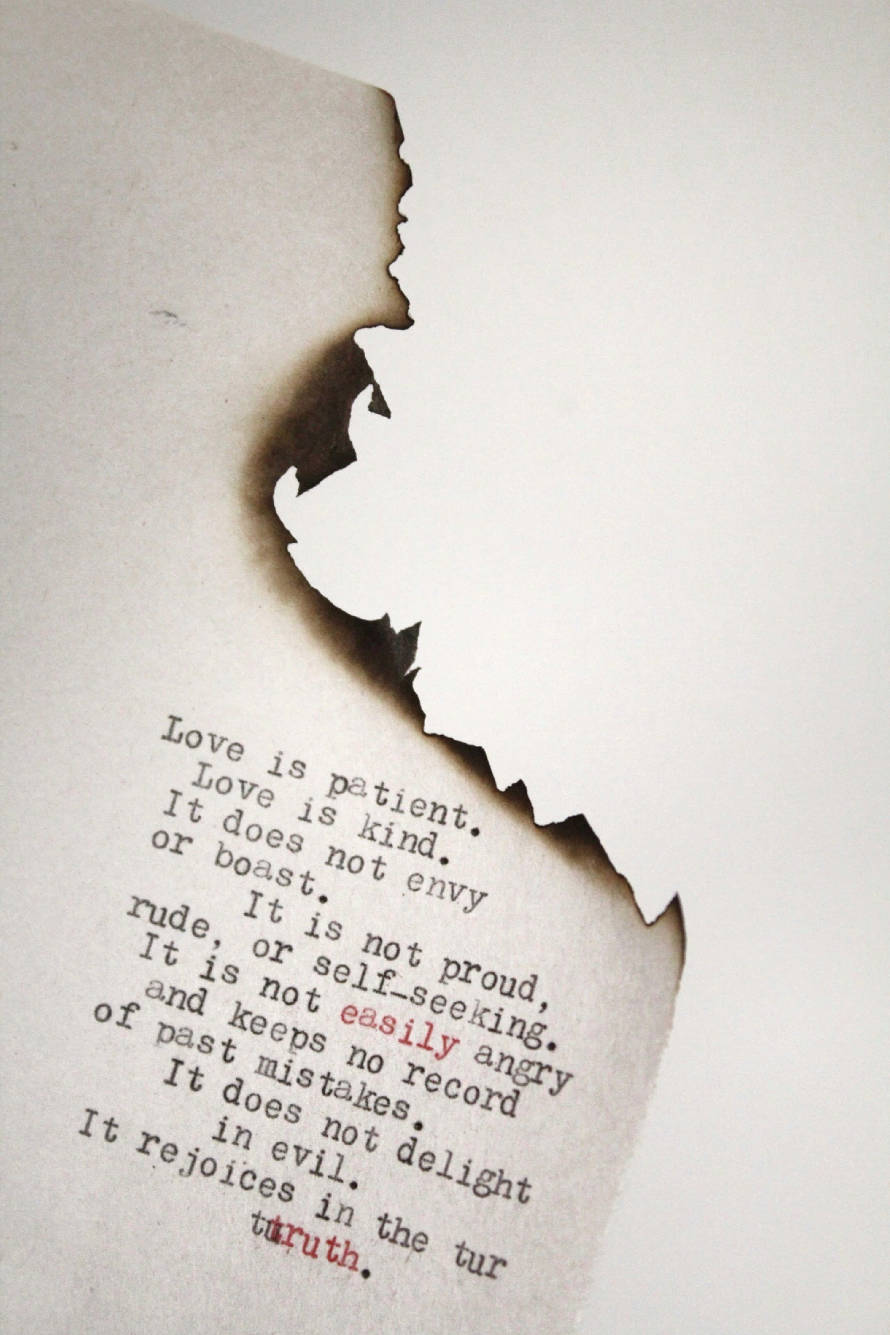 torn paper fragment, charred paper, typewritten passage on love, 4K Phone Wallpaper