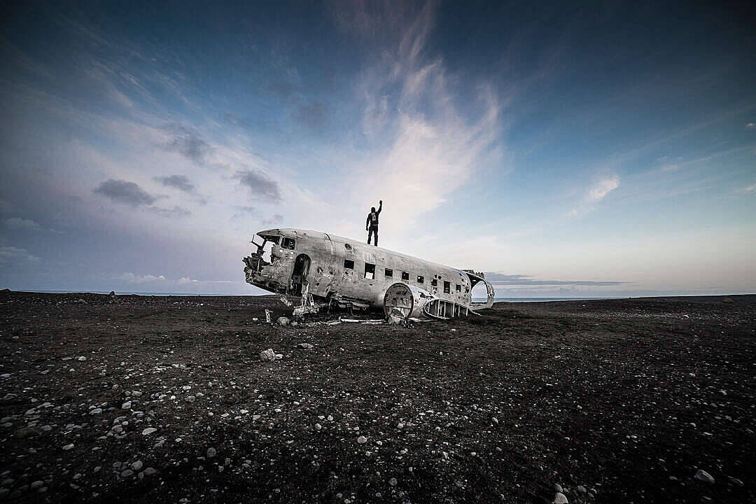 plane wreckage, barren black lava field, vast cloudy sky, SD Desktop Wallpaper