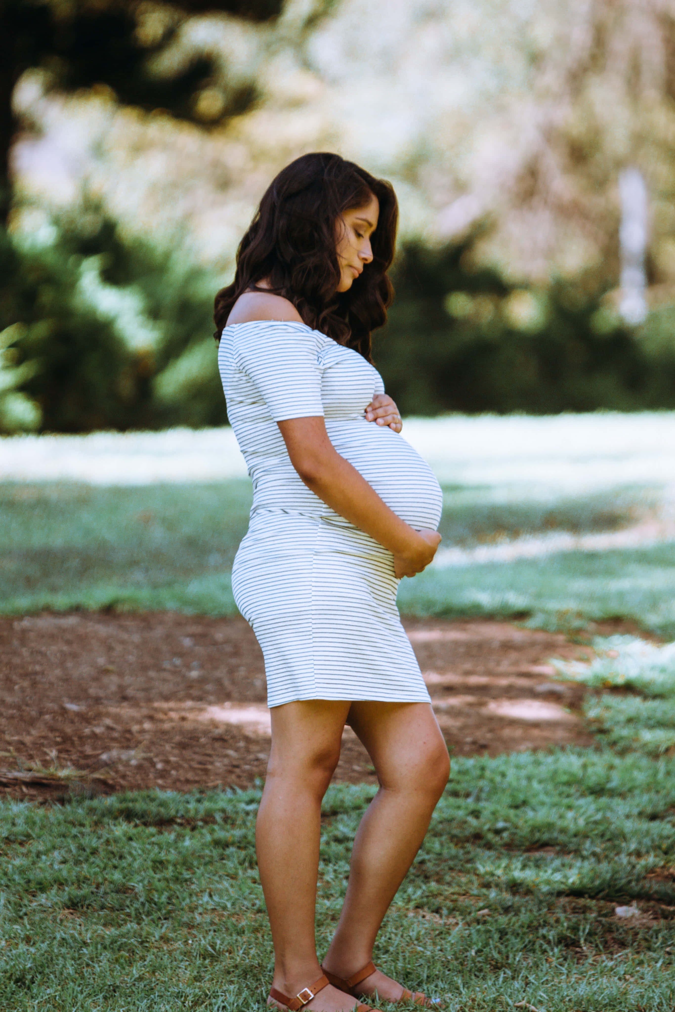 expectant mother, striped dress, sunlit grassy park, 4K Phone Wallpaper