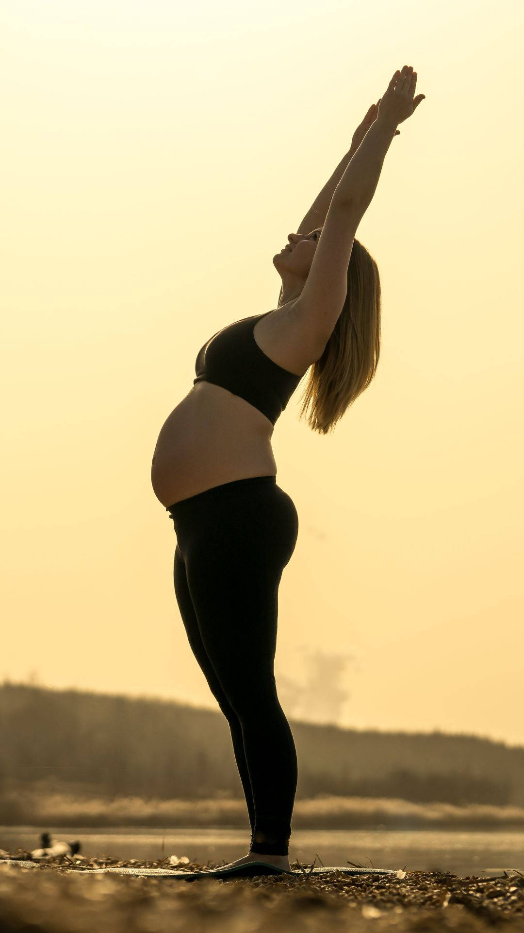 Pregnant woman, black workout gear, serene sunset, Full HD Phone Wallpaper