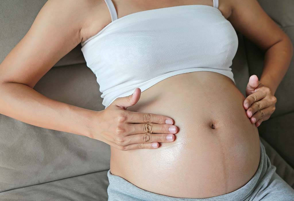 pregnant woman, rounded belly, gray couch, SD Desktop Wallpaper