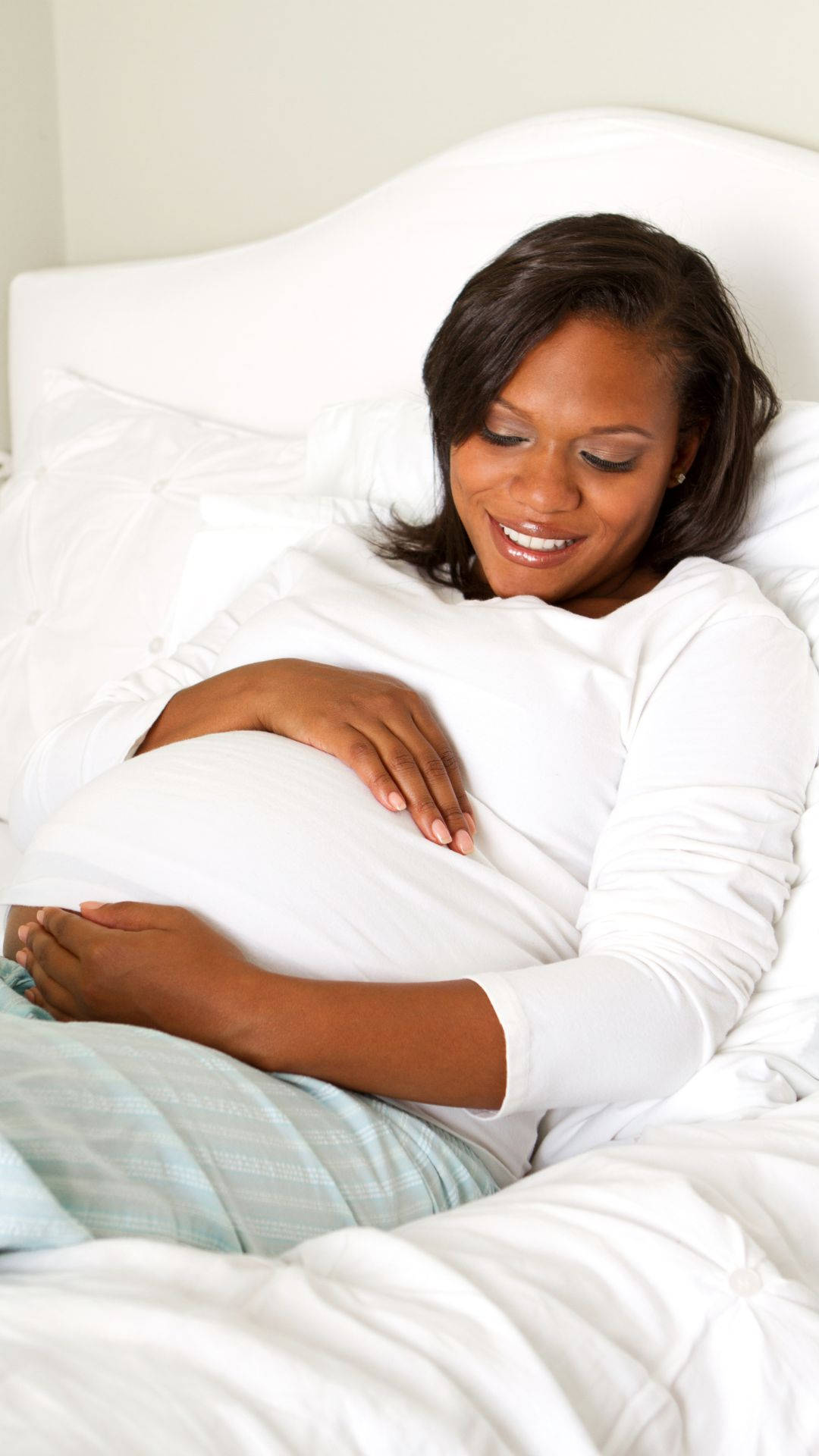 pregnancy woman, lying on bed, cradling her belly, Full HD Phone Wallpaper