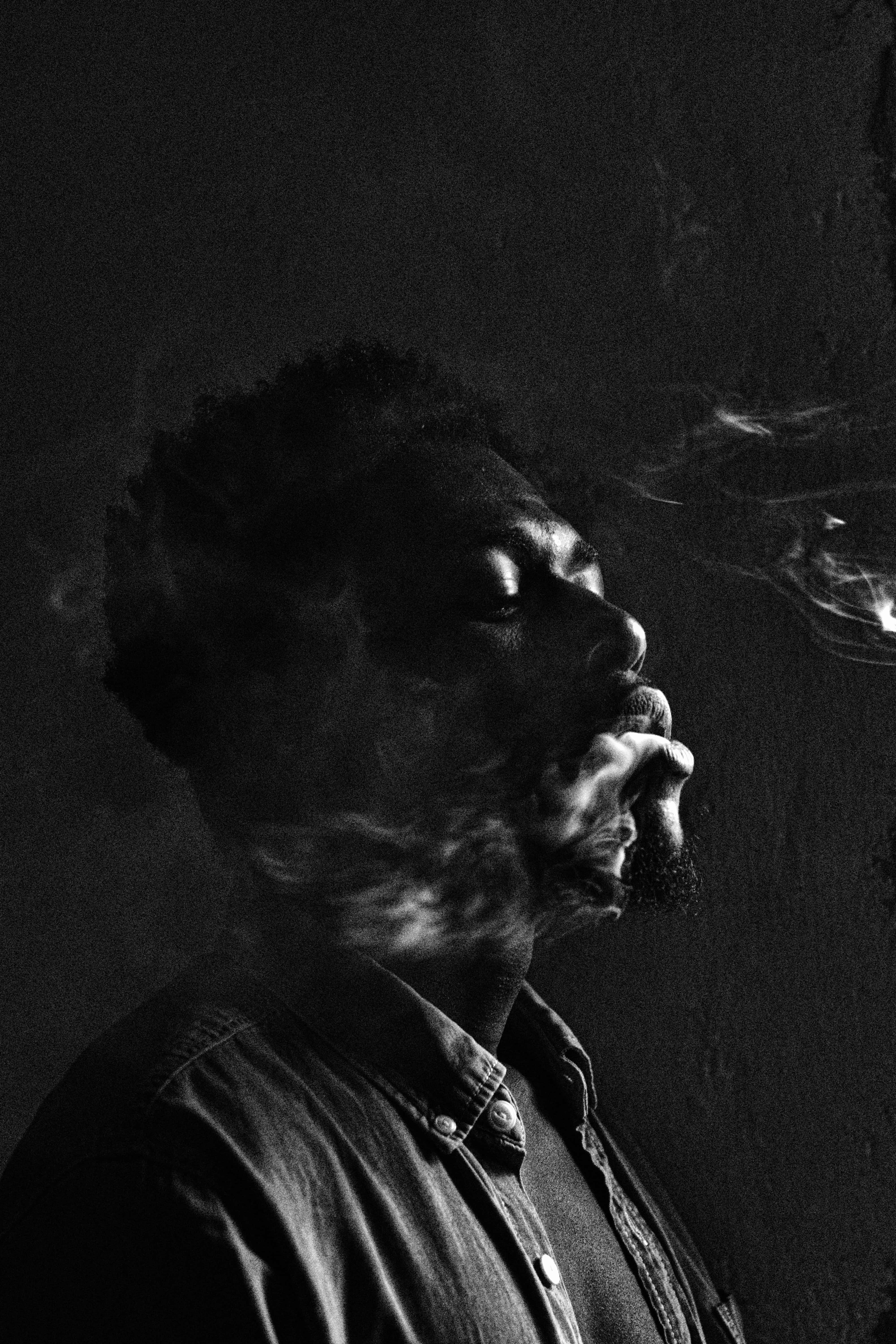 black and white portrait, dark backdrop, man in profile, 5K Phone Wallpaper