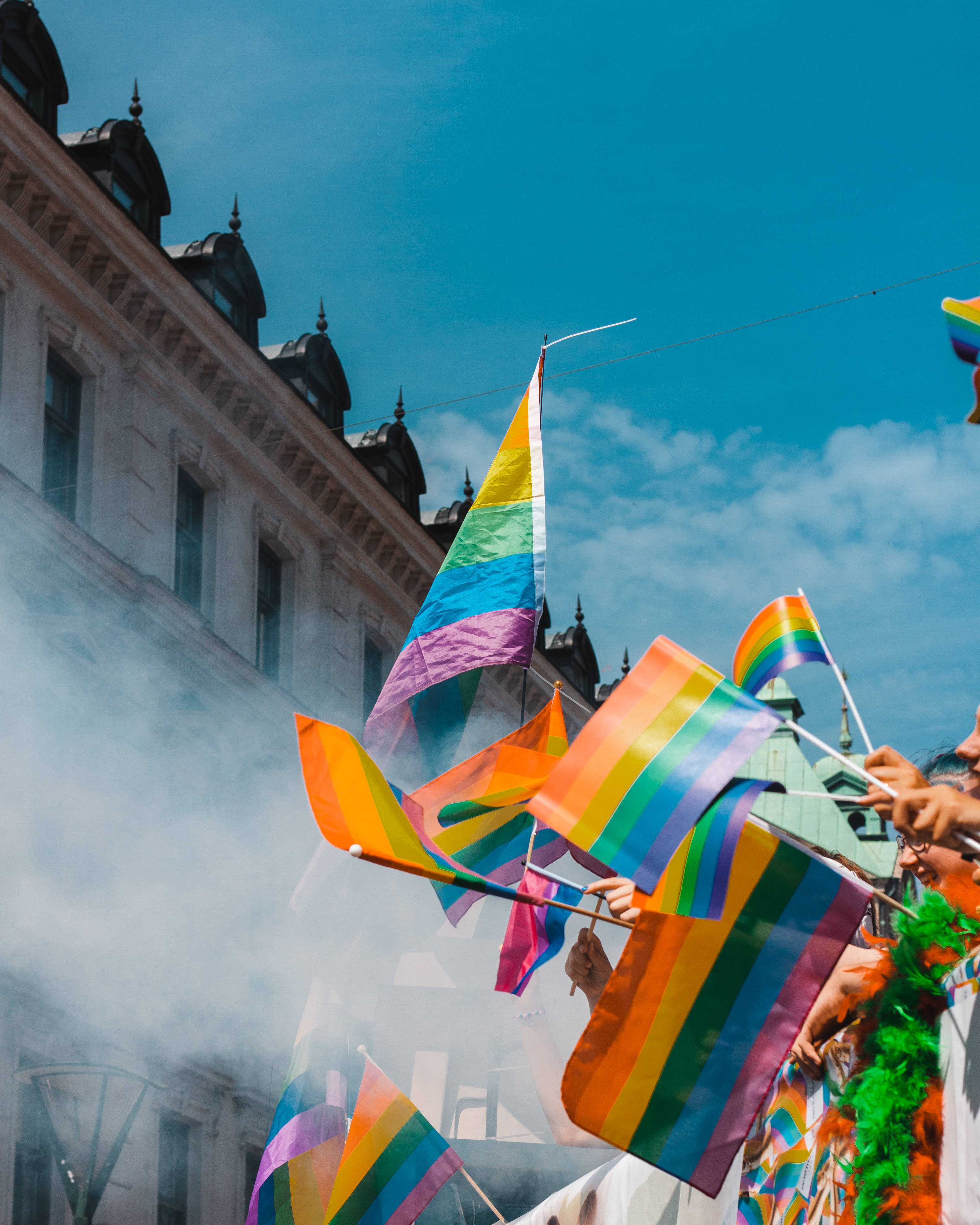rainbow flags, bright blue sky, lively street parade, 4K Phone Wallpaper