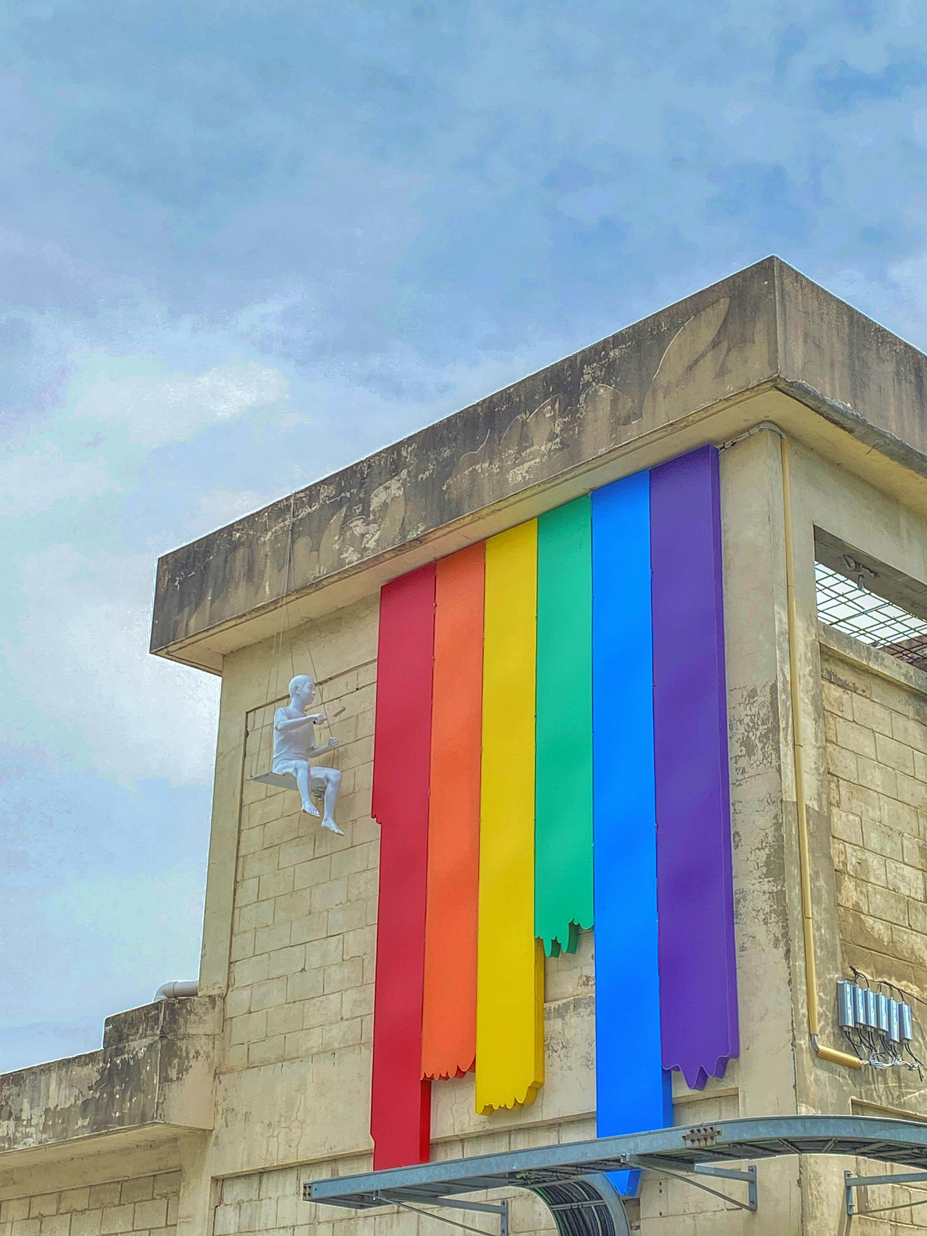 Pride flag, white statue of a child, weathered building, 4K Phone Wallpaper