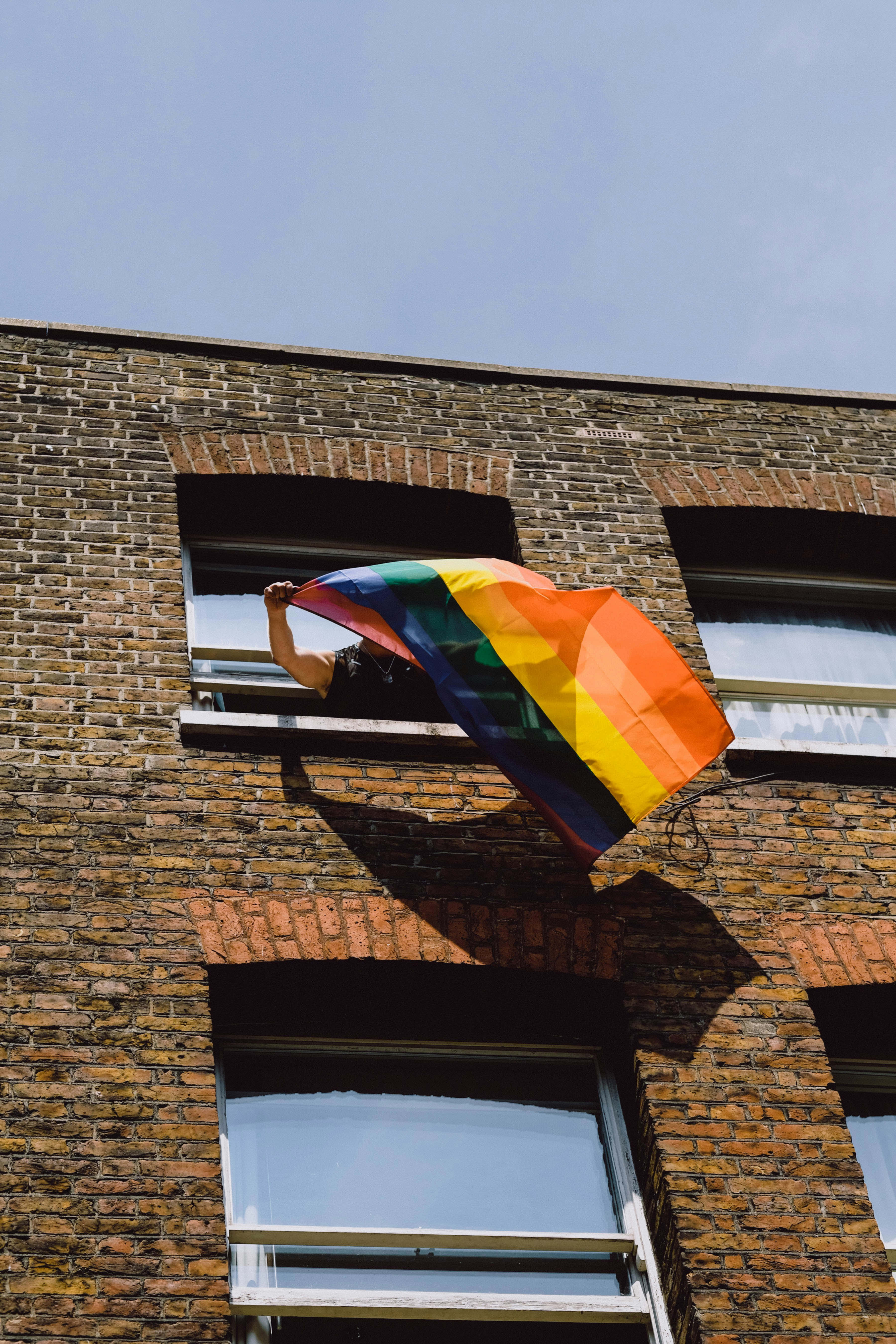 rainbow flag, brick building, clear blue sky, 5K Phone Wallpaper