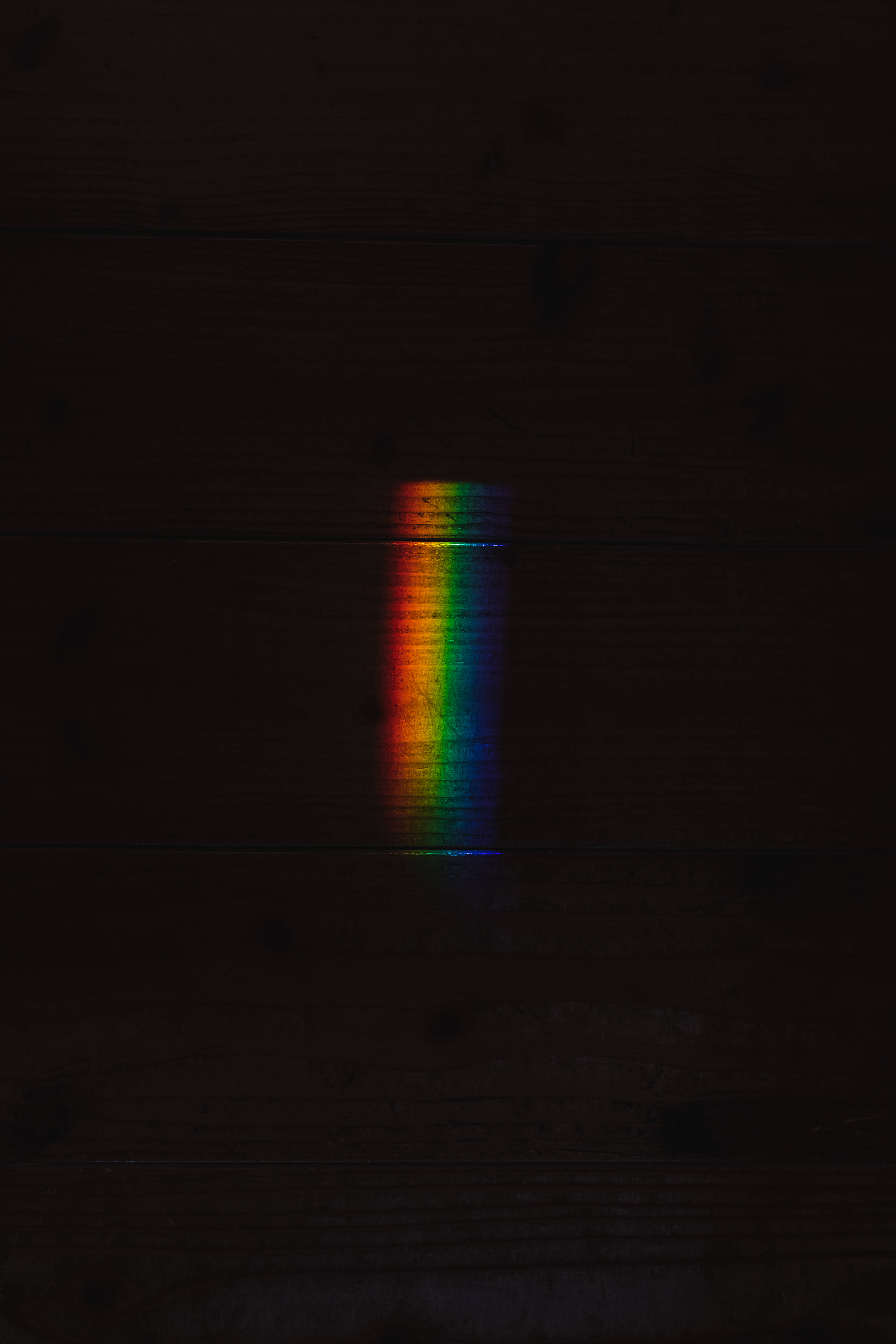 rainbow prism, dark wooden surface, minimalist composition, 8K Phone Wallpaper