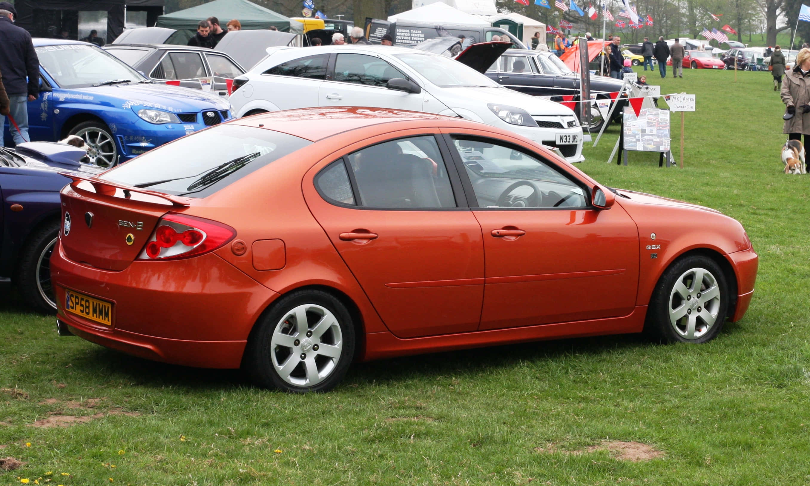Proton Gen-2, vibrant orange, outdoor car show, 2K Desktop Wallpaper
