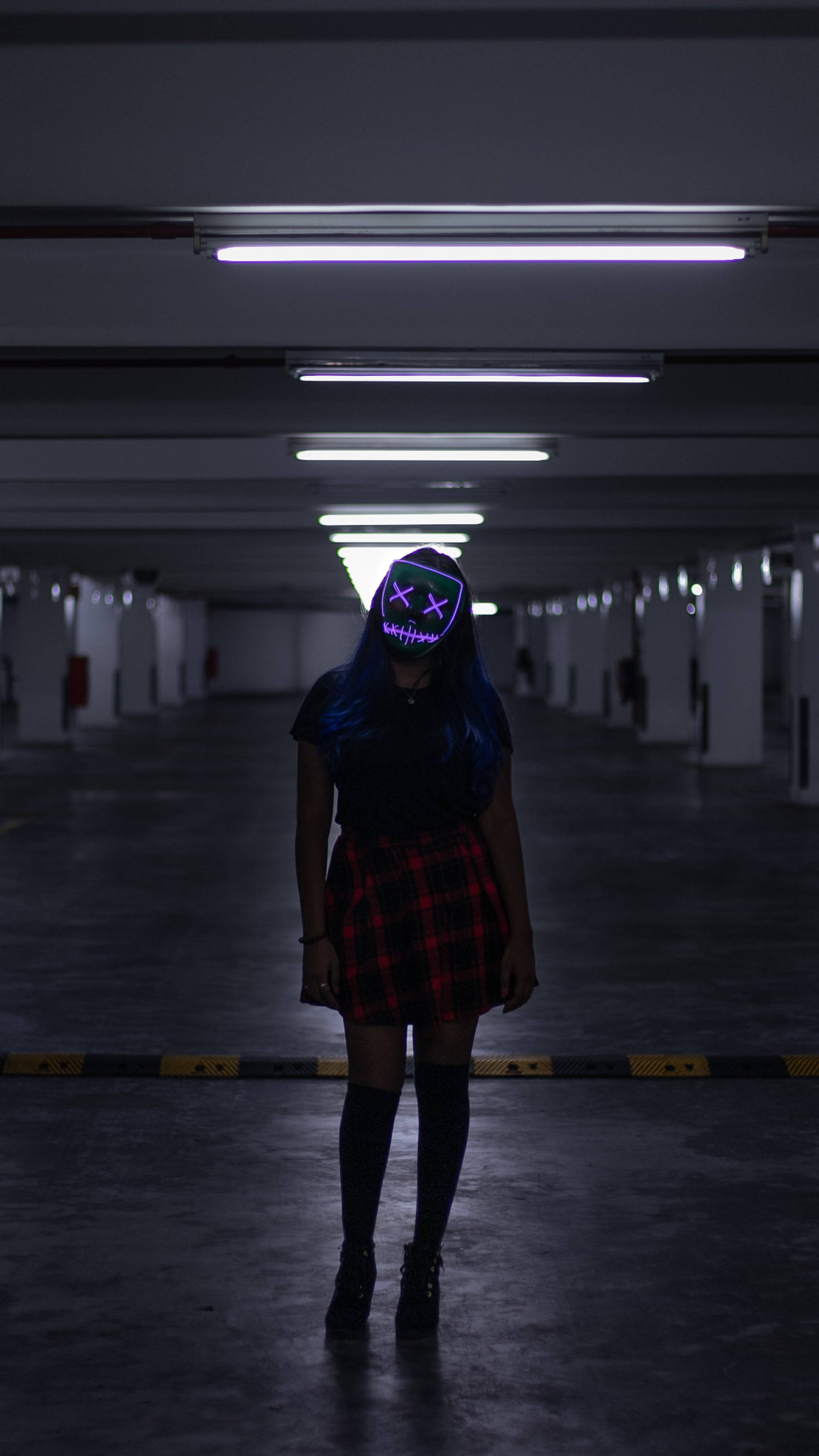 Purge Mask, glowing purple skull mask, dimly lit underground parking garage, 2K Phone Wallpaper