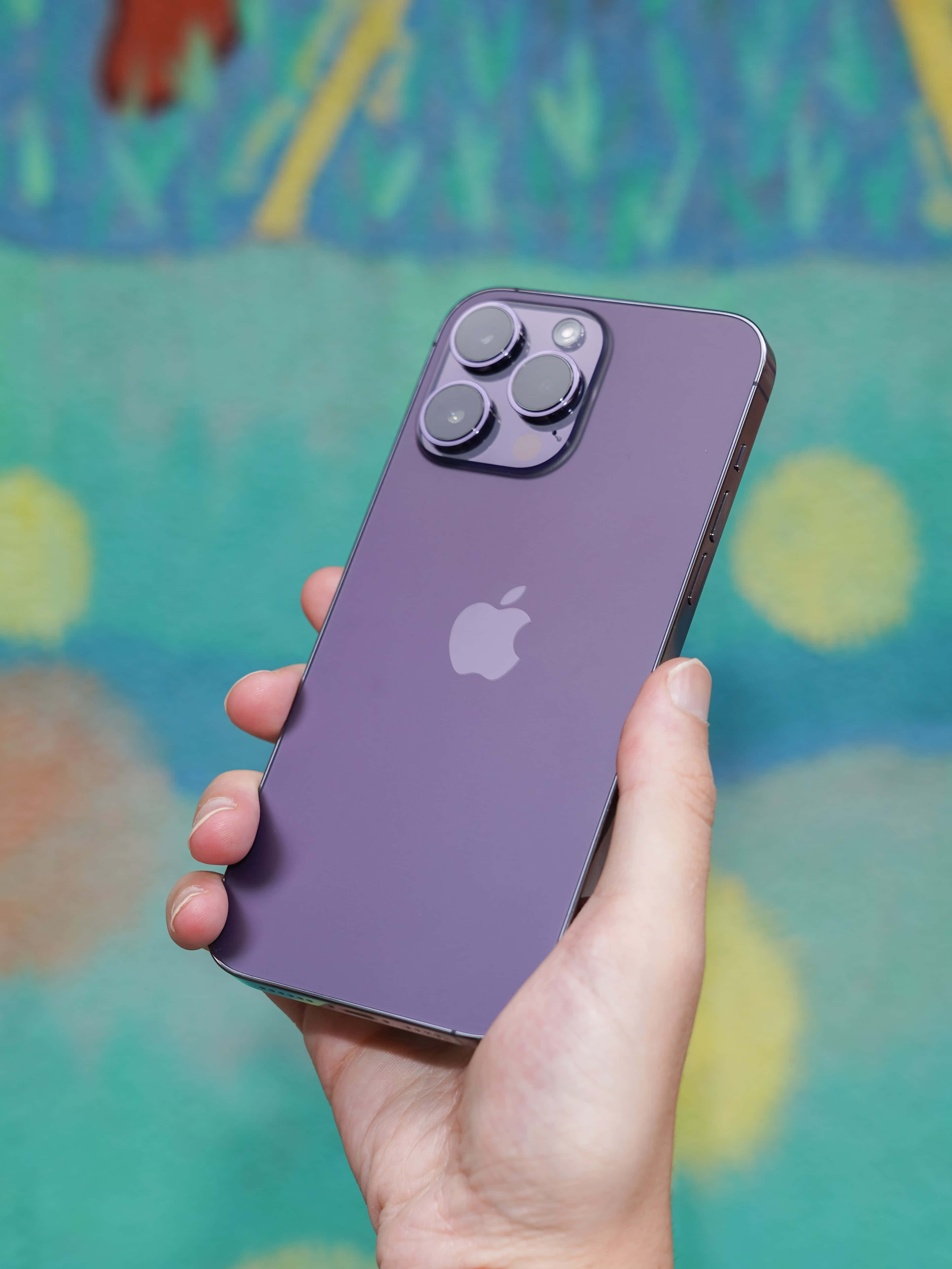 Purple iPhone 14 Pro Max, hand, colorful abstract mural, 5K Phone Wallpaper
