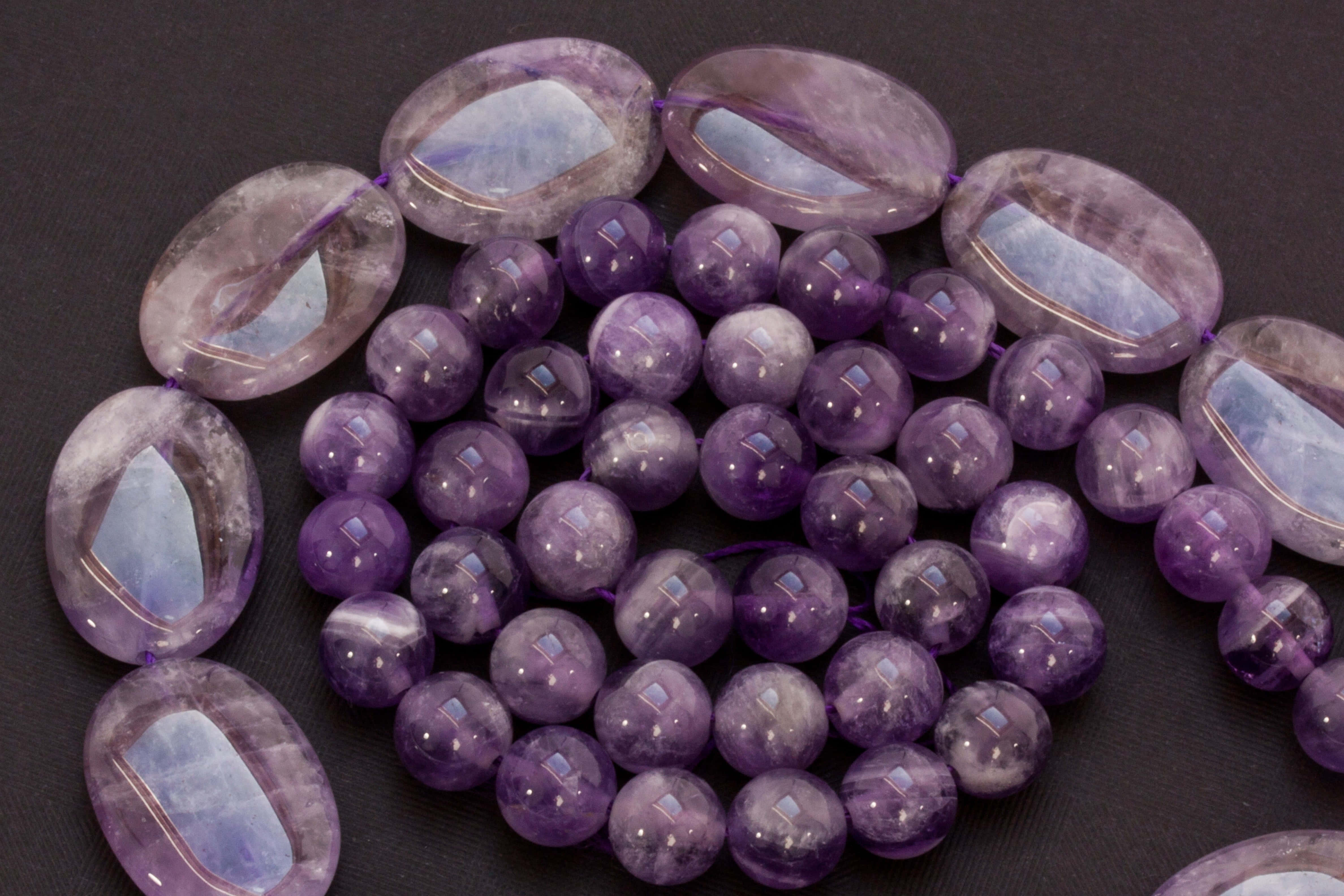 glossy amethyst beads, oval and round shapes, dark textured surface, 4K Desktop Wallpaper