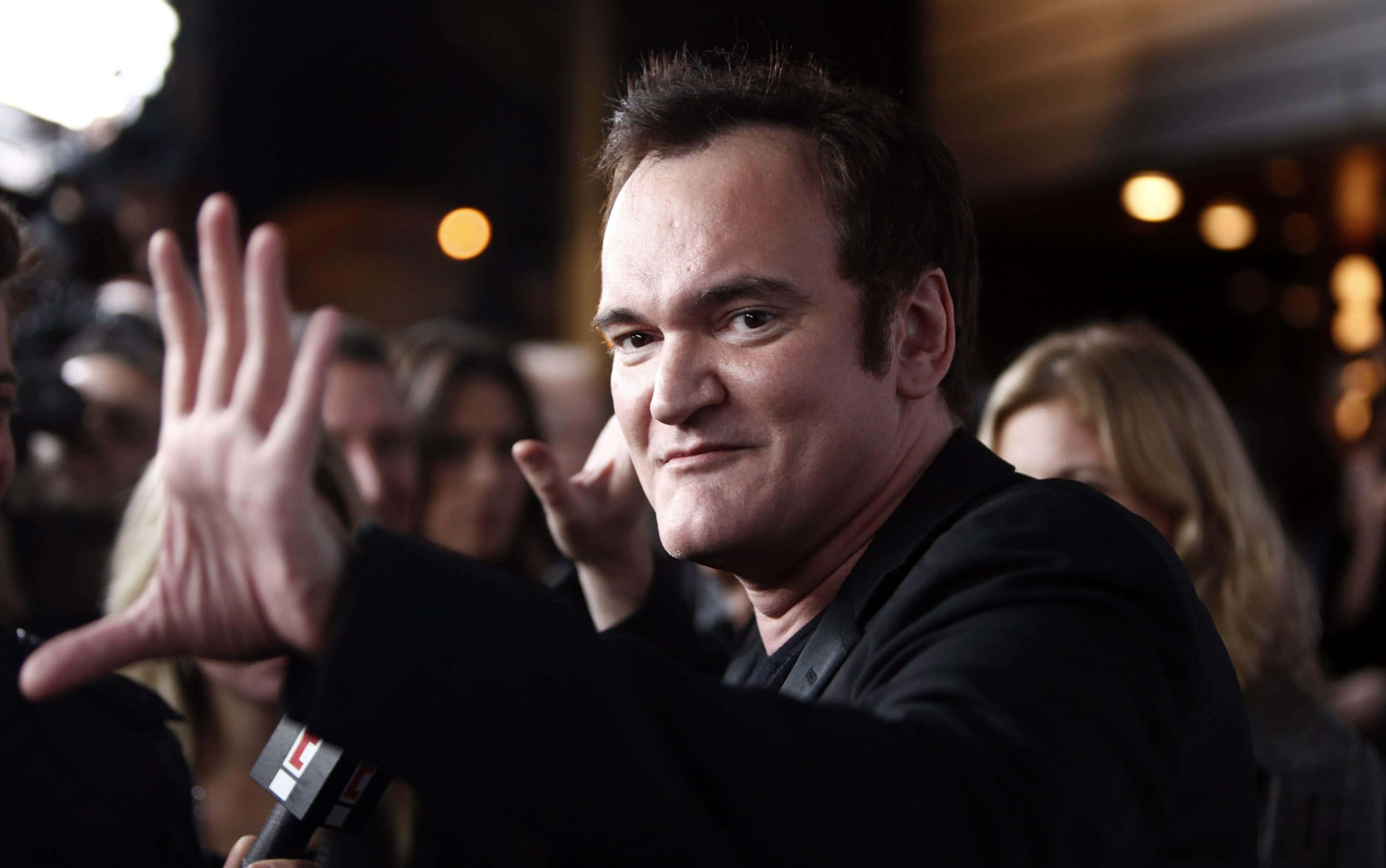 Quentin Tarantino, confident smirk, crowded event, 2K Desktop Wallpaper