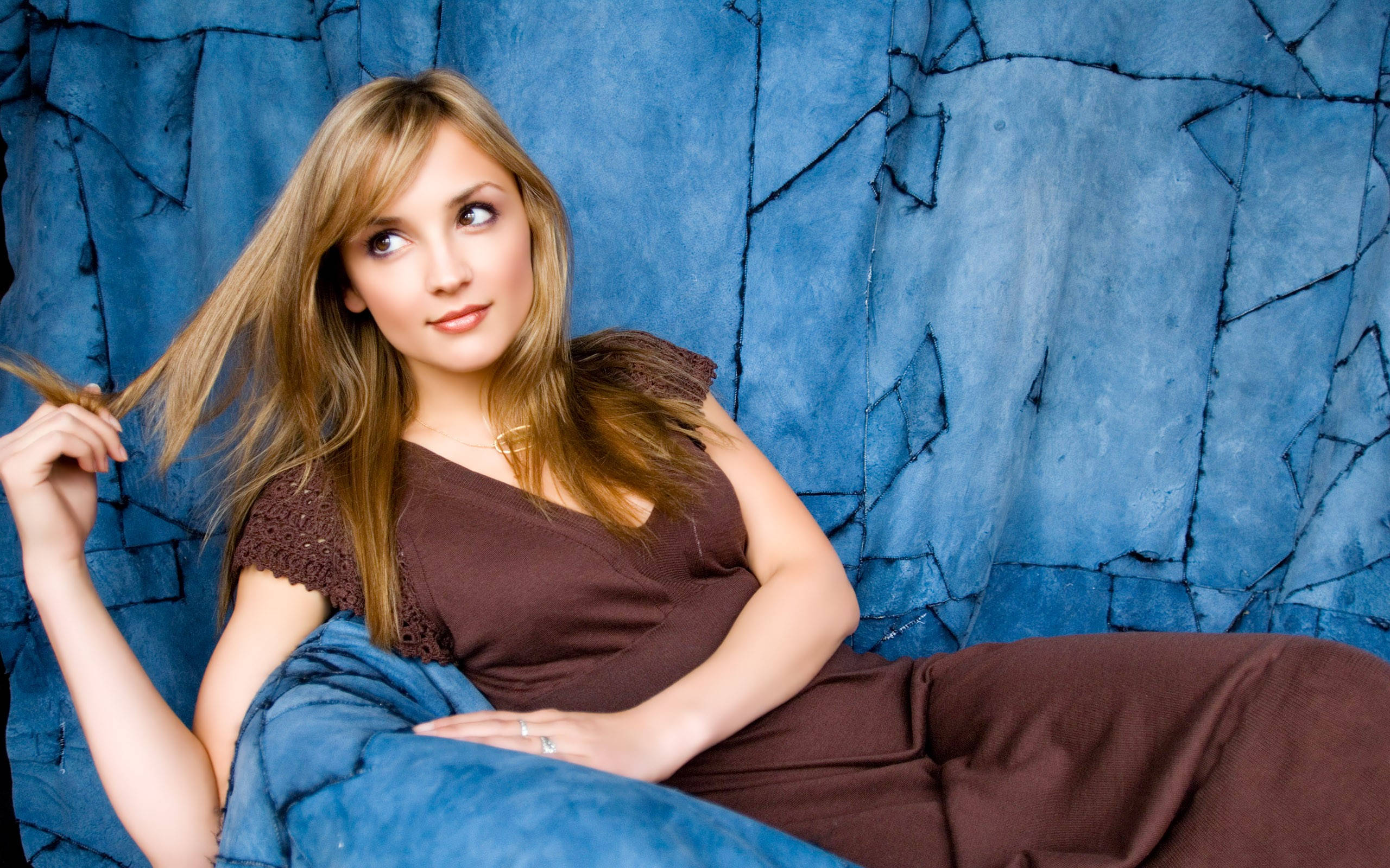 Rachael Leigh Cook, long blonde hair, textured blue couch, 2K Desktop Wallpaper