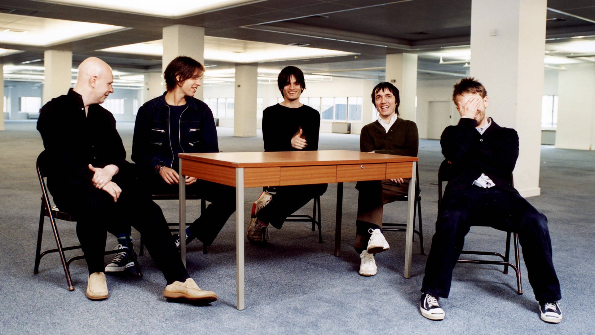 Radiohead, wooden table, vast empty office space, Full HD Desktop Wallpaper