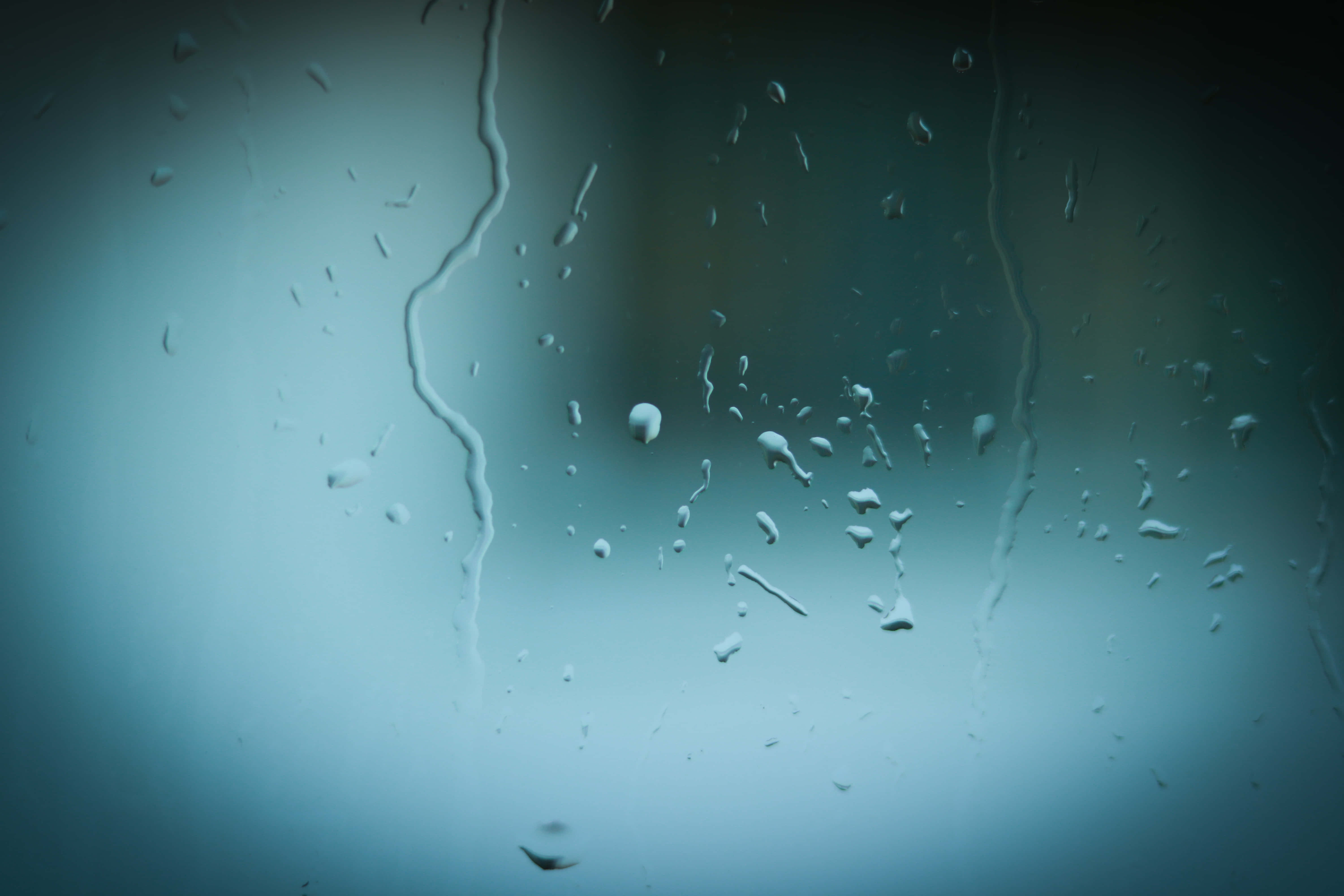 glass pane, raindrops, soft blue-gray blurred background, 5K Desktop Wallpaper