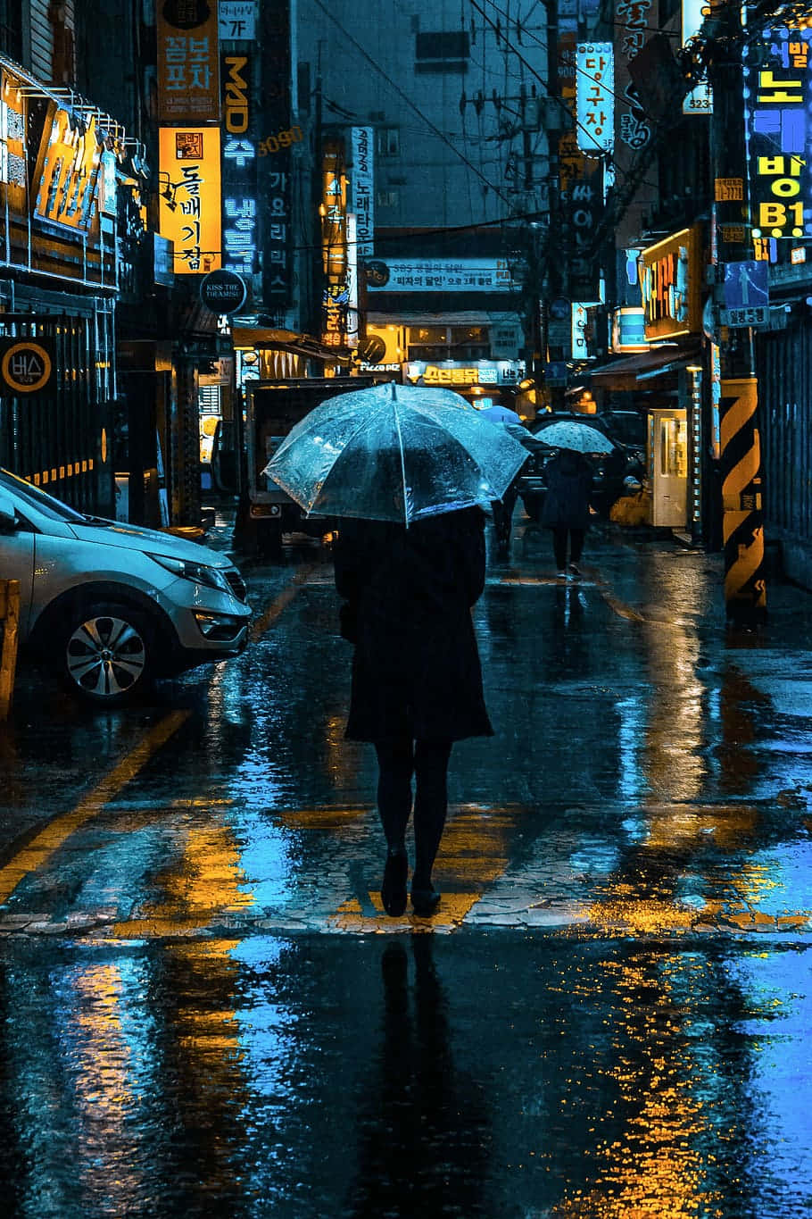 neon-lit rain-soaked Korean street, vibrant yellow and blue lights, lone figure with an umbrella, HD Phone Wallpaper
