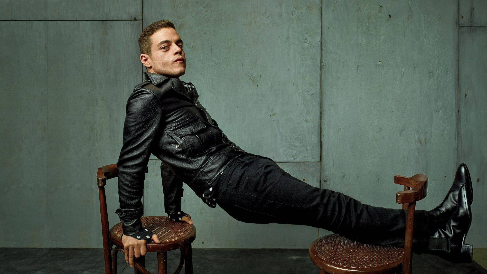Rami Malek, black leather jacket, wooden chairs, Full HD Desktop Wallpaper
