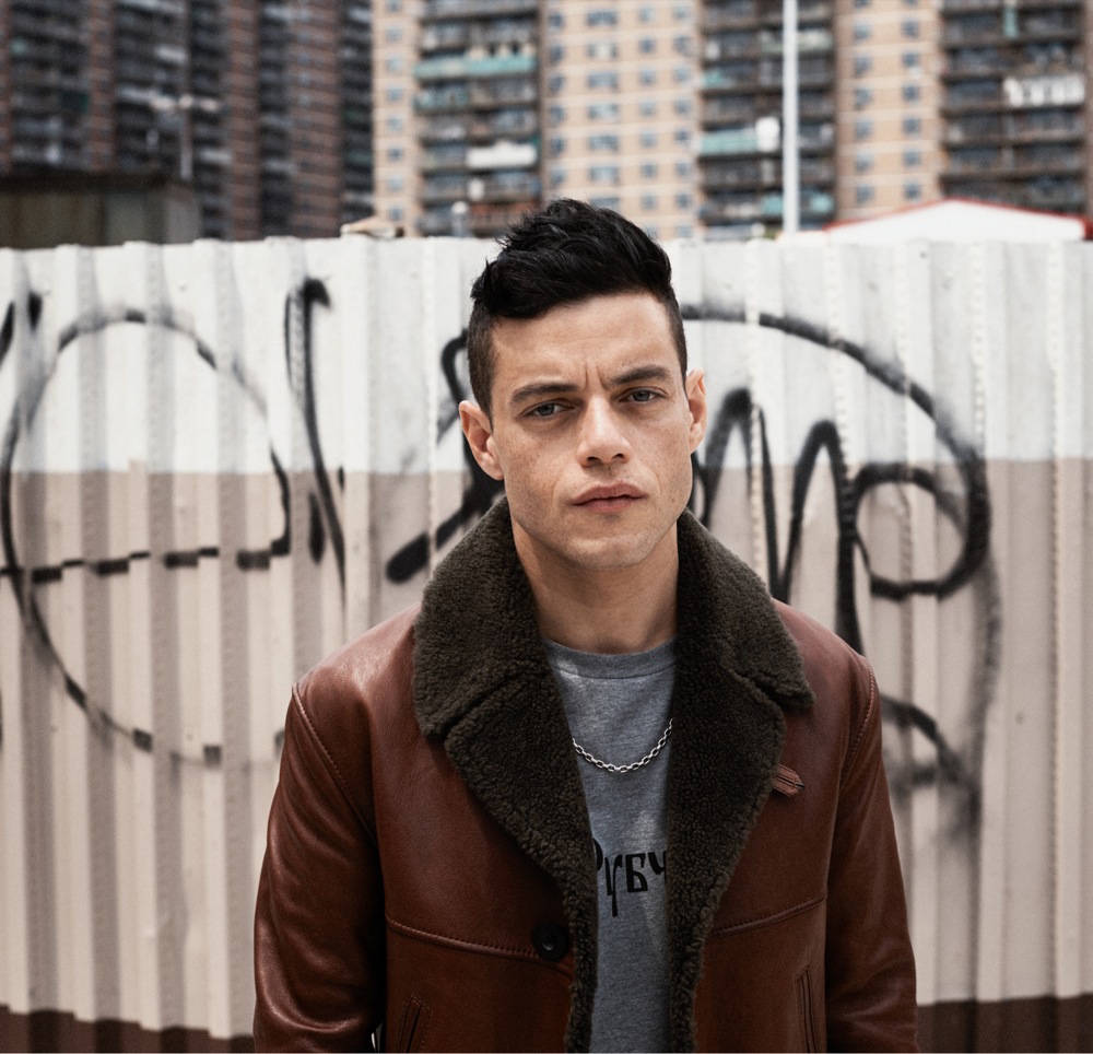 Rami Malek, graffiti-covered metal fence, brown leather jacket, SD Desktop Wallpaper