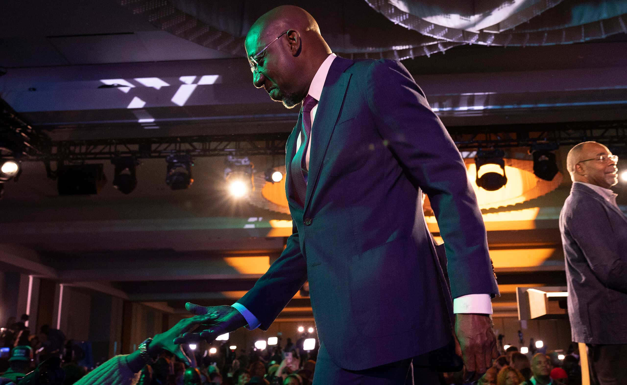 Raphael Warnock, sharp suit, dramatic stage lights, 2K Desktop Wallpaper